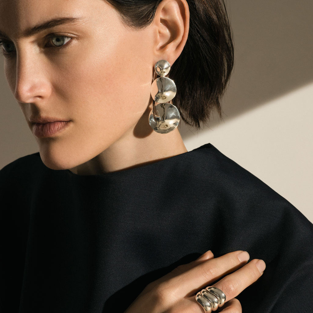 Woman wearing AGMES 0.925 sterling silver long circular round triple drop earrings.