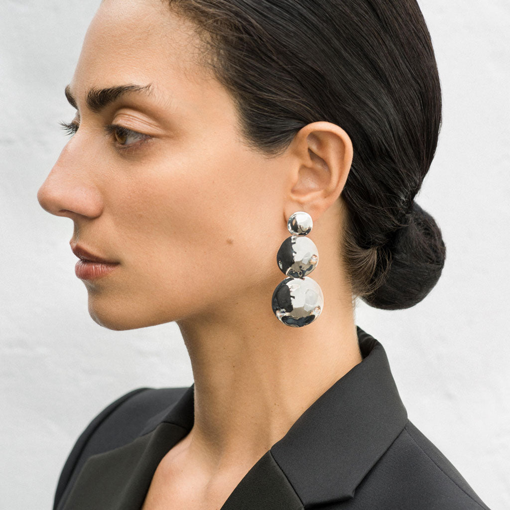 Woman wearing AGMES 0.925 sterling silver long circular round triple drop earrings.