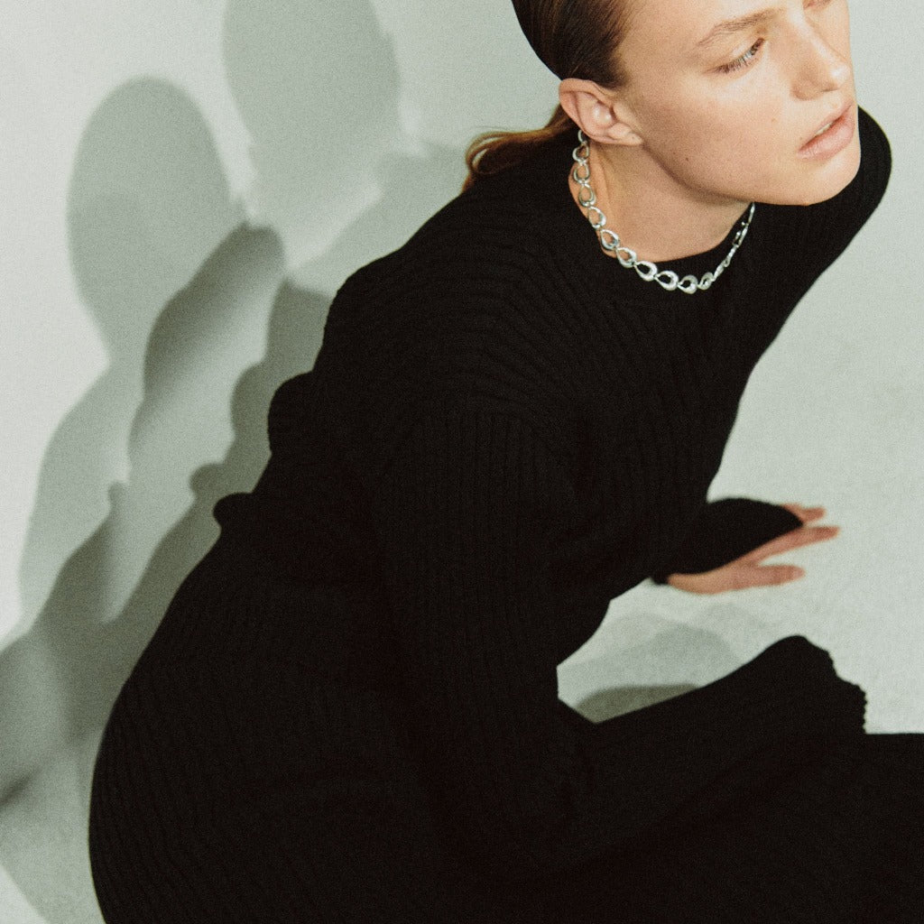 Model wearing AGMES .925 sterling silver sculptural link Thin Tilda Necklace and black dress.