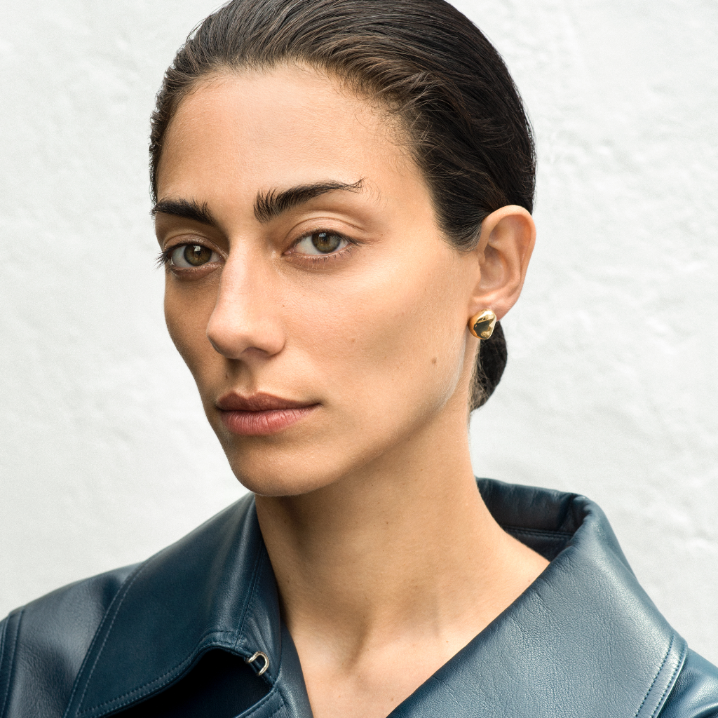Woman wearing AGMES 18k gold vermeil sculpted round stud earrings.