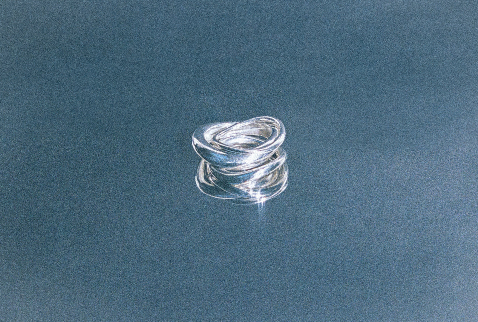 AGMES .925 sterling silver wavy sculptural Small Astrid Ring, Medium AstridRing, and Large Astrid Ring stacked on dark blue background.