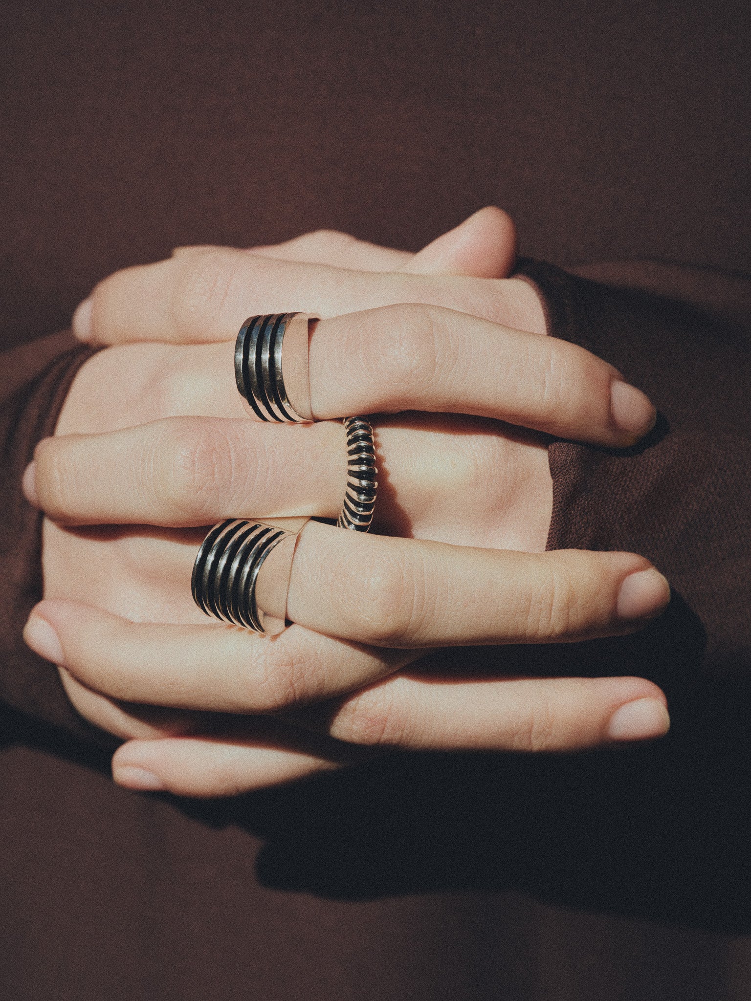 Person wearing AGMES .925 Sterling Silver ridged Bertrand Ring, Boeri Ring, and Wide Boeri Ring. 