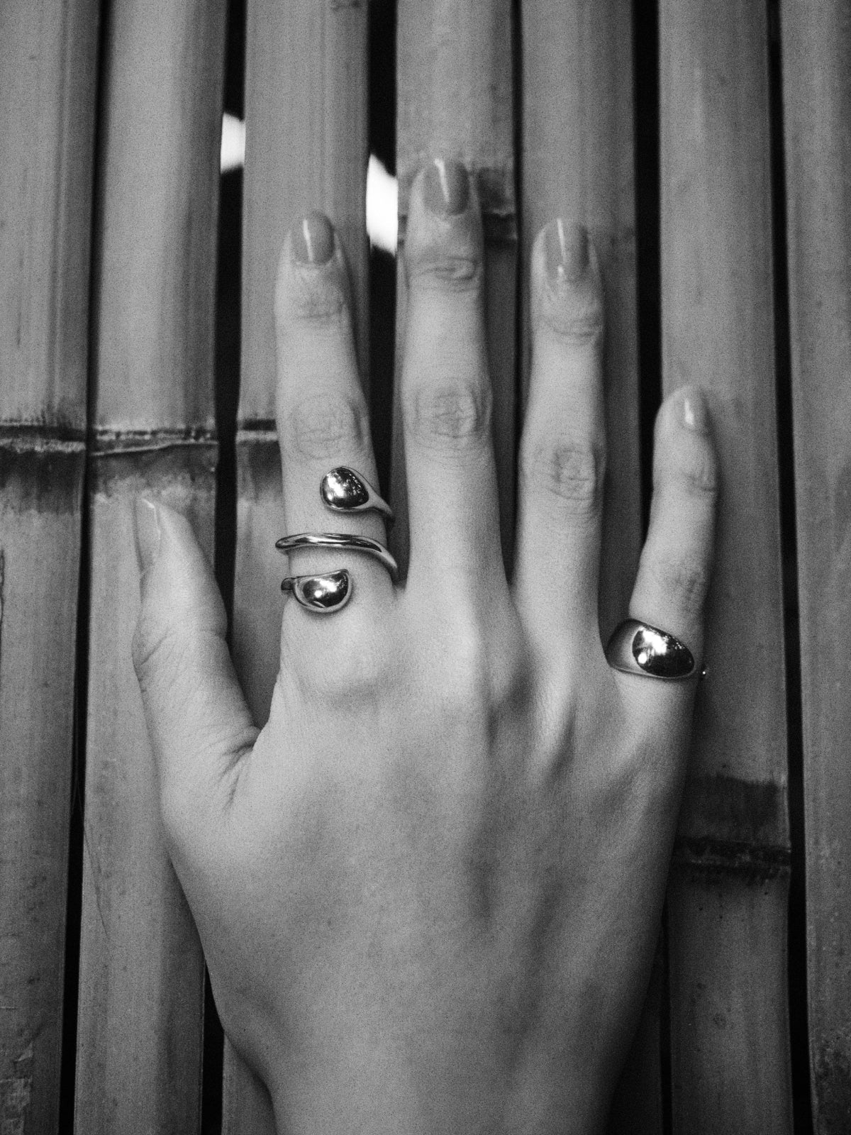 Person wearing AGMES 0.925 sterling silver mini cuff Sienna Ring and Dual Flora Ring.