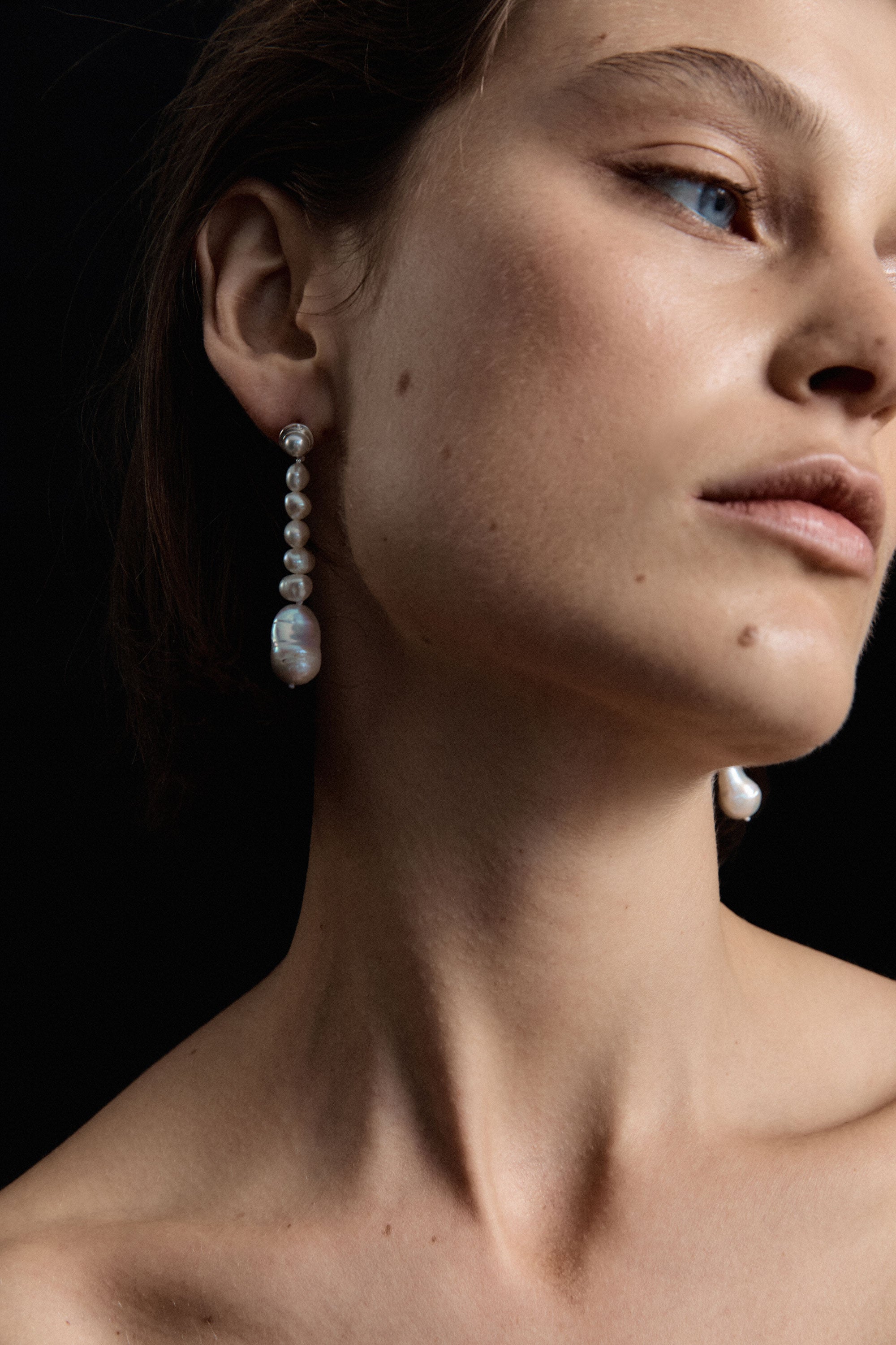 Woman wearing AGMES pearl drop earrings 0.925 sterling silver.