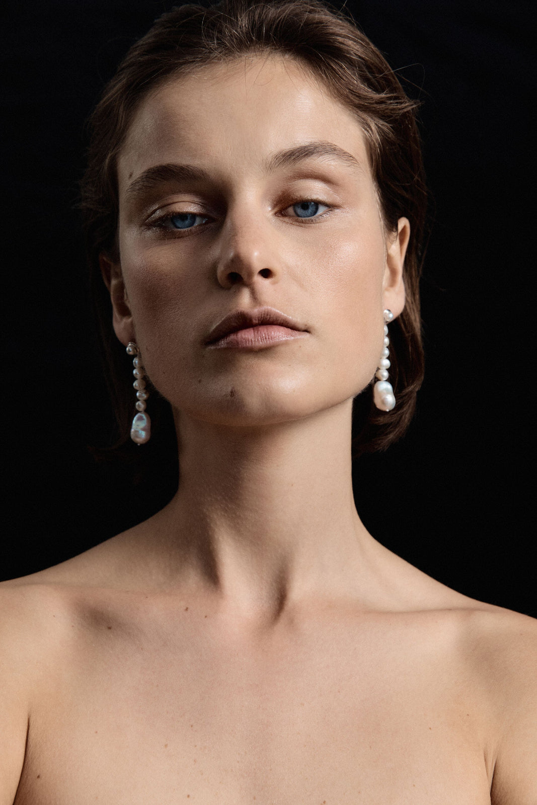 Woman wearing AGMES pearl drop earrings 0.925 sterling silver.