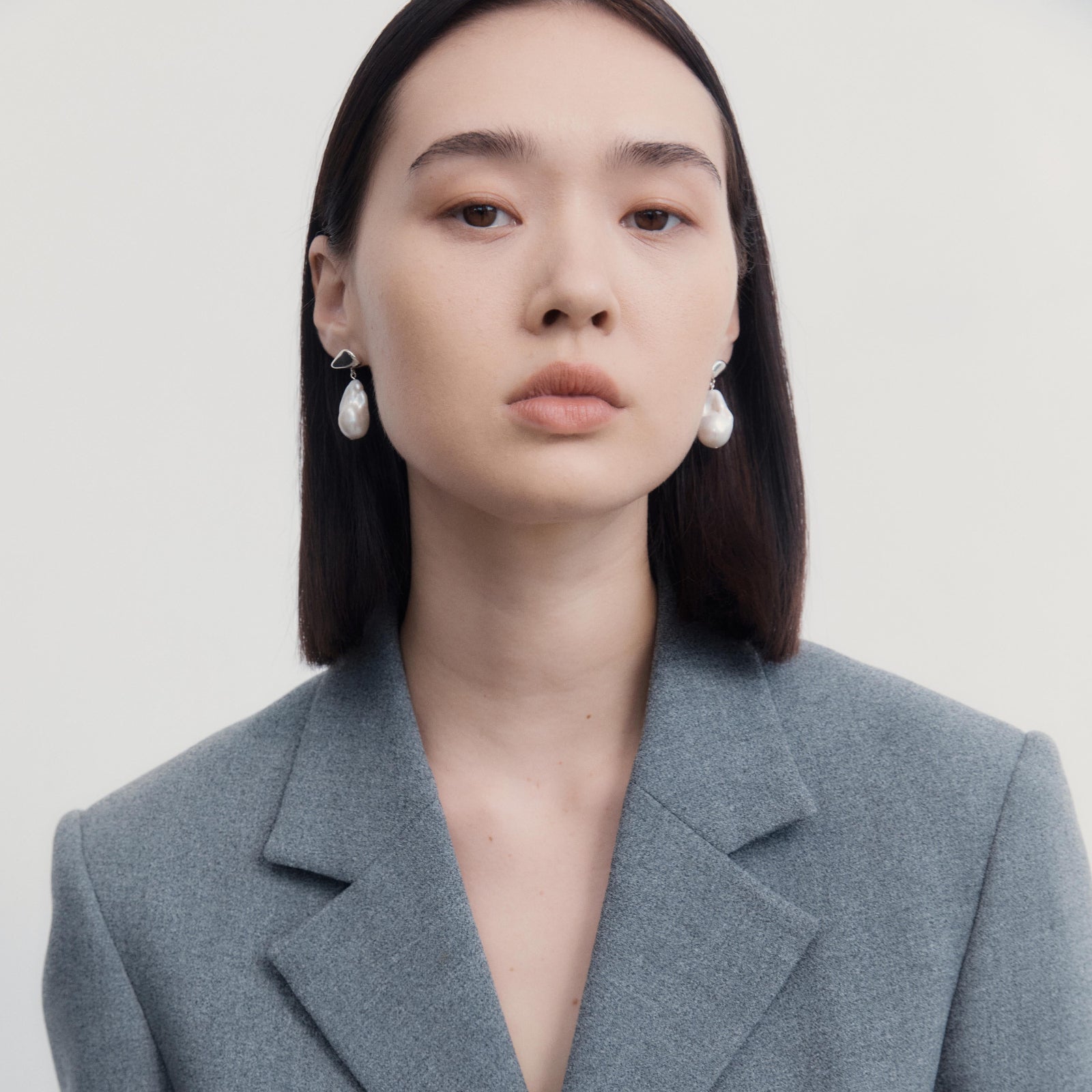 Woman wearing AGMES .925 Sterling Silver Ila Earrings with Baroque Pearl Drop. 