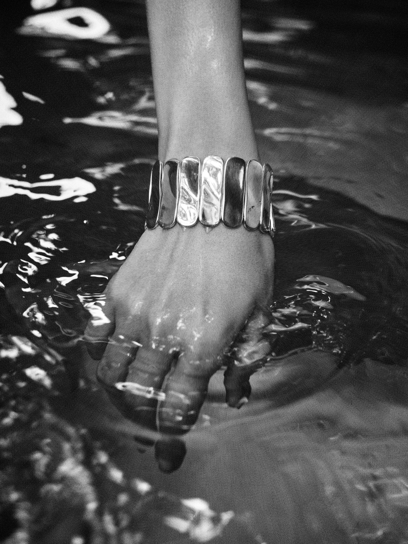 Person wearing AGMES 0.925 sterling silver Ilona Bracelet with adjustable elastic band with hand in water.