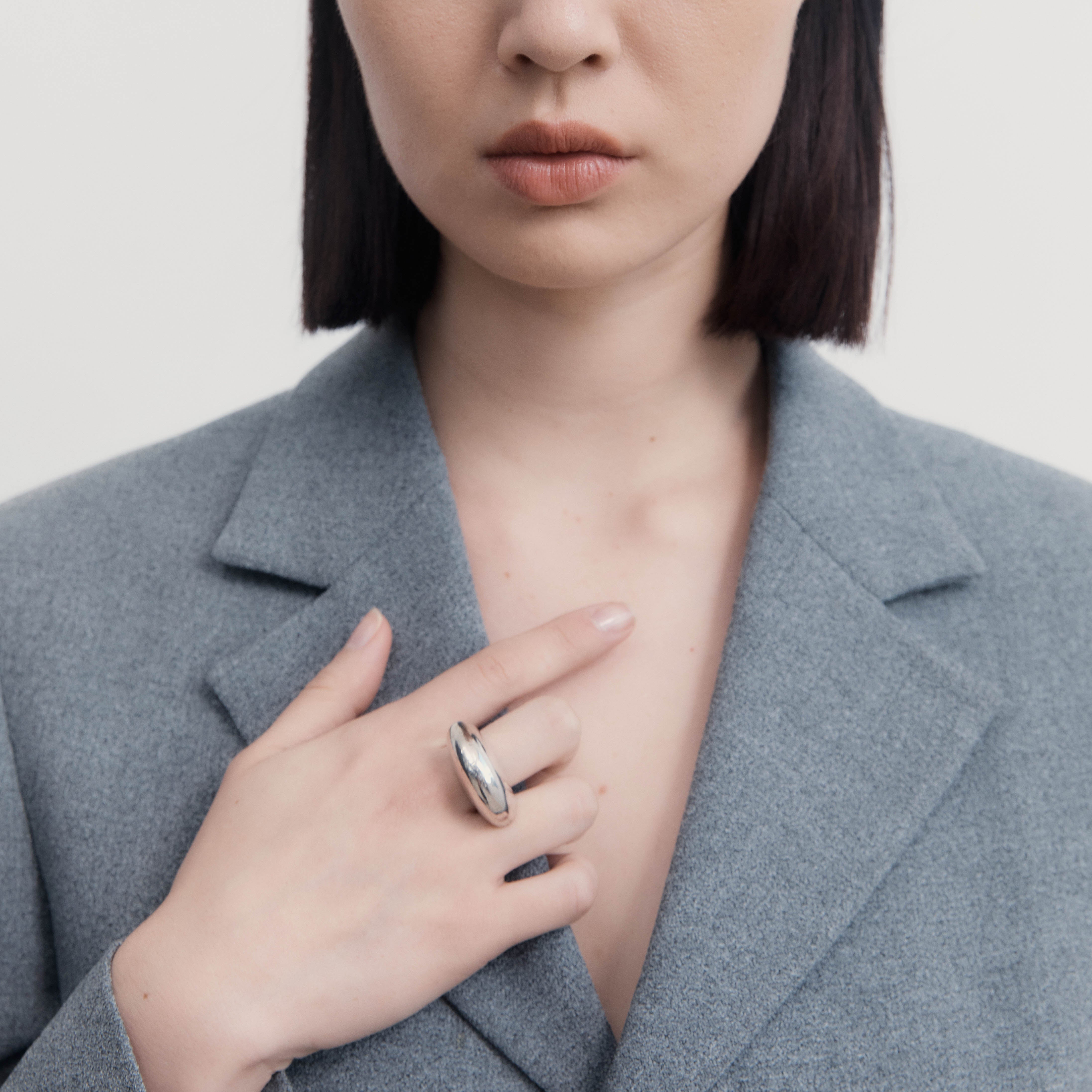 Woman wearing AGMES .925 Sterling Silver Jouve Ring and grey blazer. 