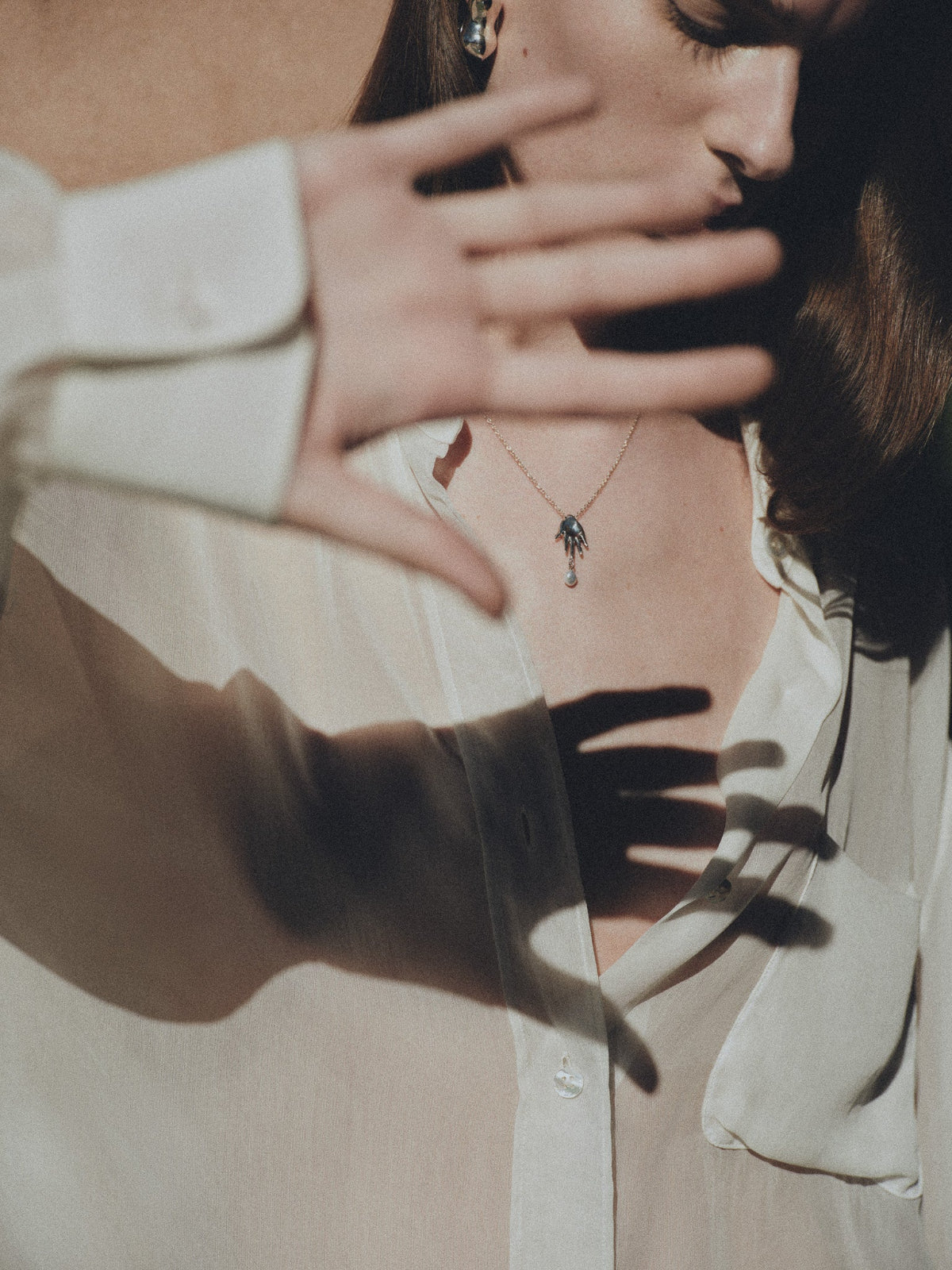 Woman wearing AGMES .925 Sterling Silver mini lee abstract hand pendant with freshwater pearl. 
