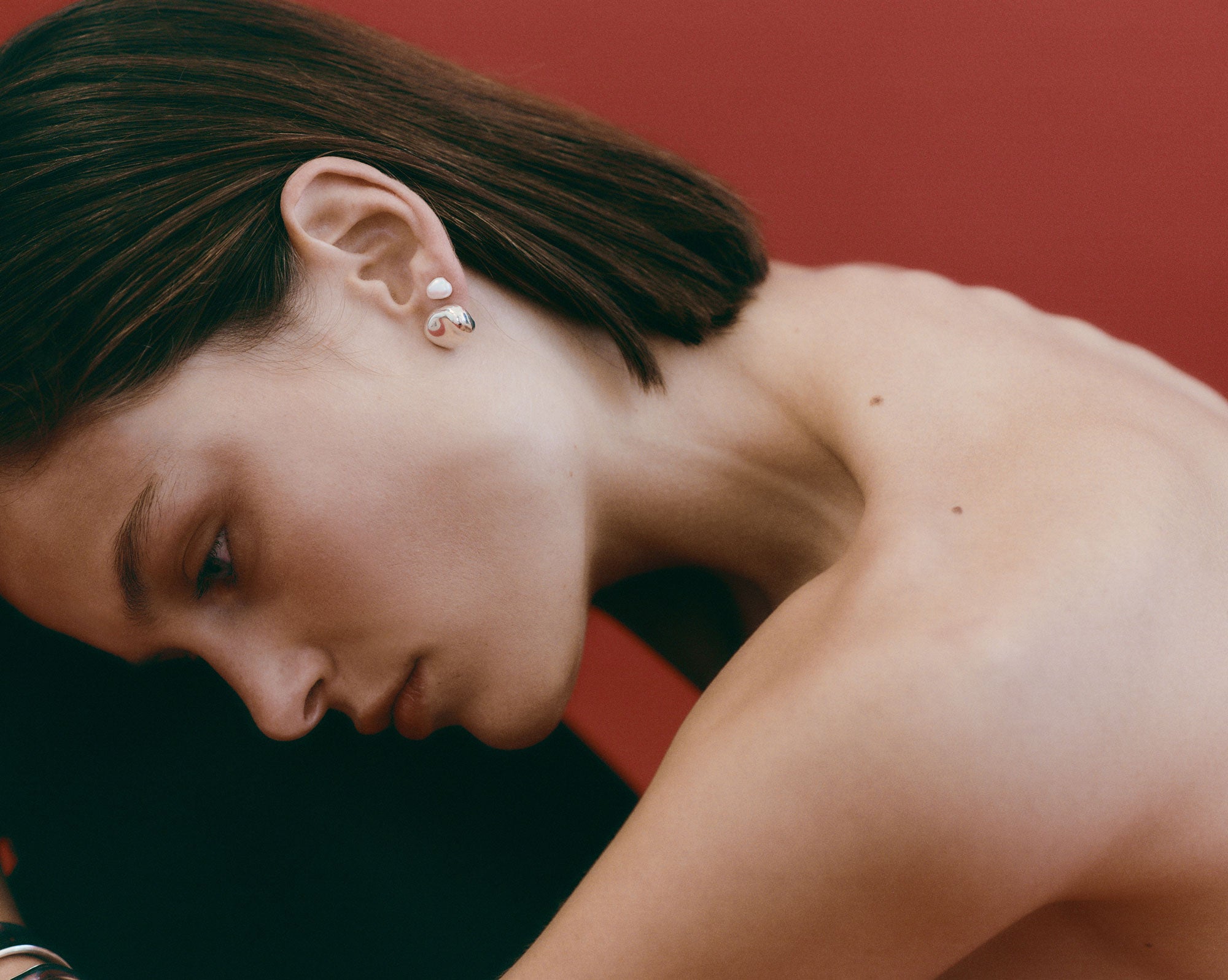 Woman wearing AGMES pearl stud earrings.