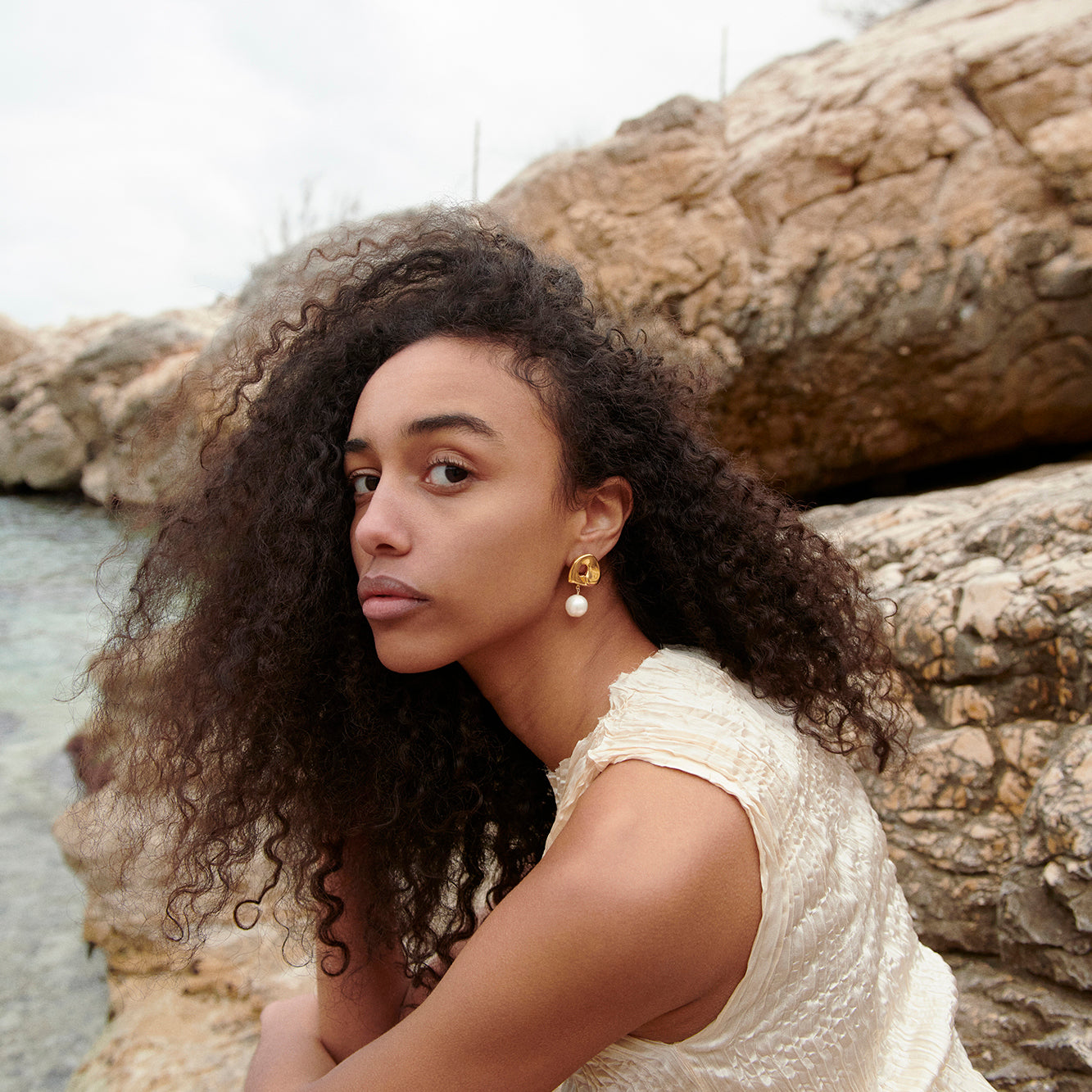 Woman wearing the AGMES 18K Gold Vermeil Sandra Clip-on Earrings with Freshwater Pearl drop. 