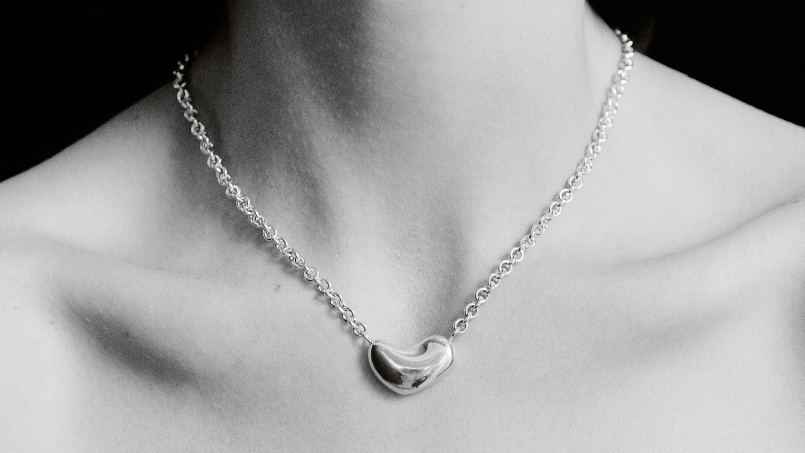 Person wearing AGMES .925 Sterling Silver Small Sculpted  Heart Pendant II on chain necklace. 