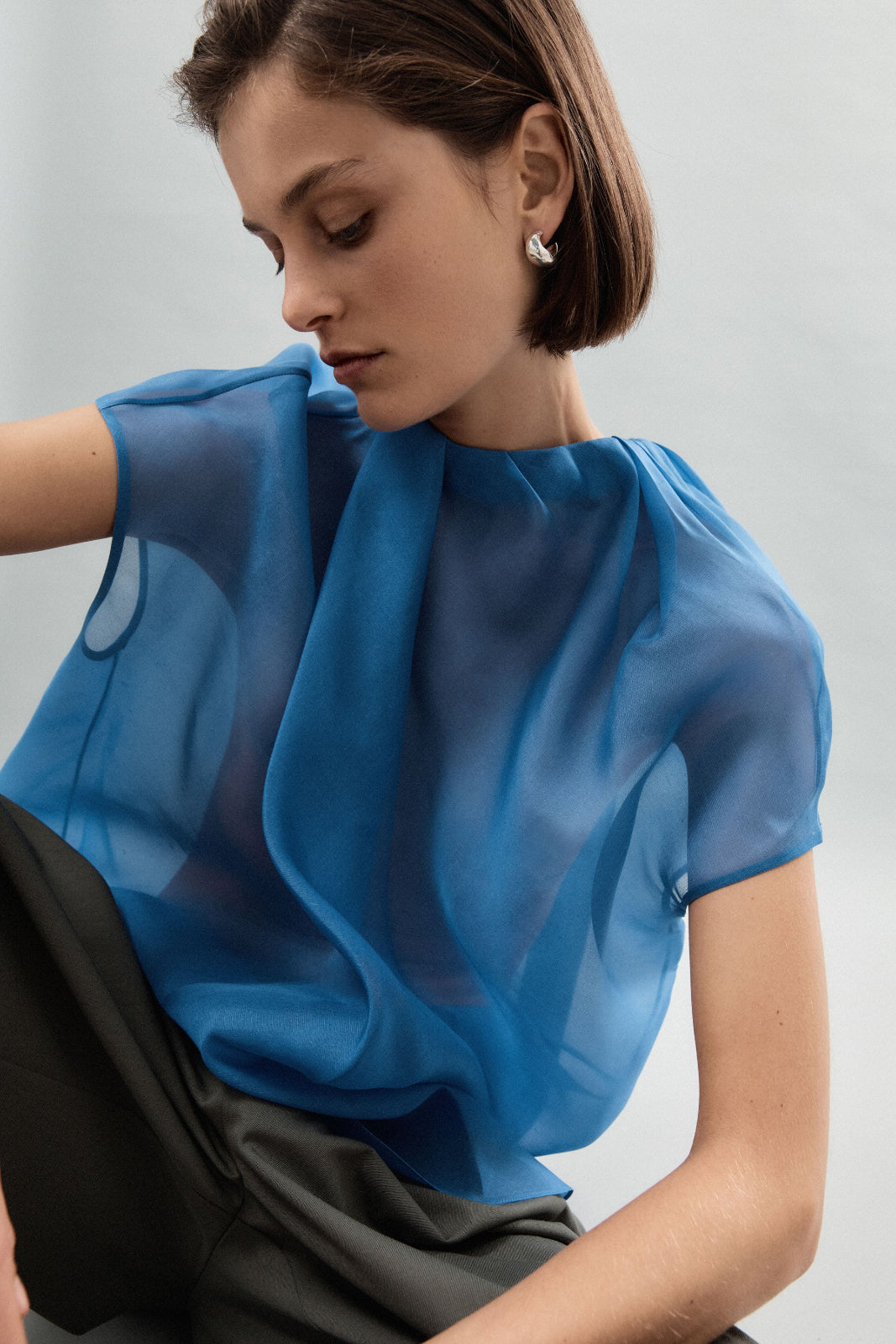 Woman wearing AGMES 0.925 sterling silver small hoop earrings.