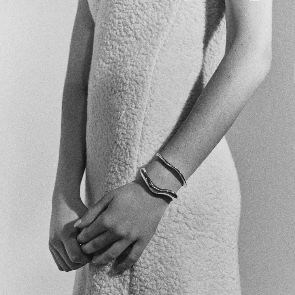 Woman wearing AGMES 0.925 sterling silver abstract small and medium Astrid cuff set.