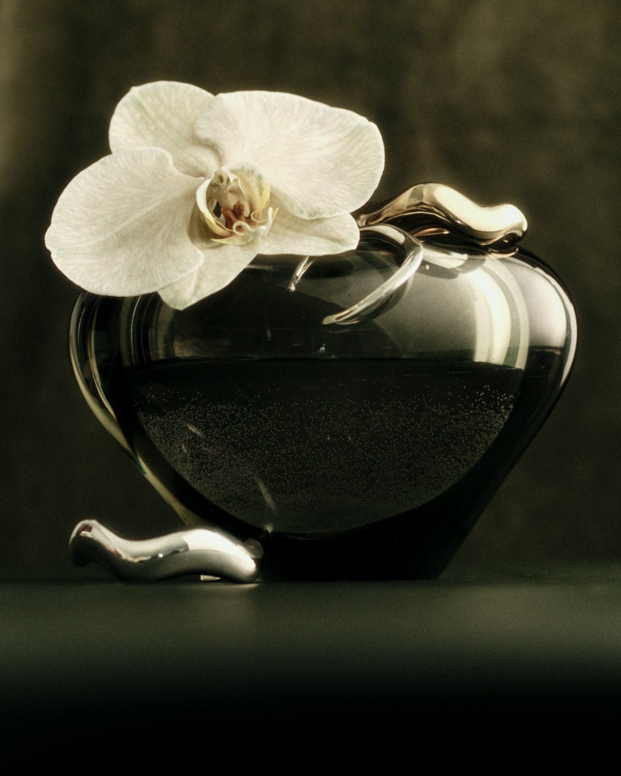 AGMES 0.925 sterling silver abstract small, medium, and large Astrid cuff set on green vase with orchid flower.