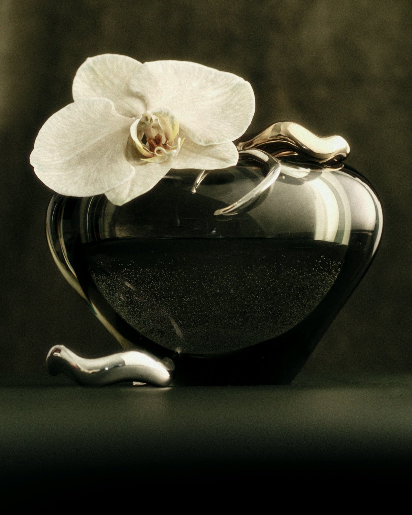 AGMES 0.925 sterling silver abstract small, medium, and large Astrid cuff set on green vase with orchid flower.