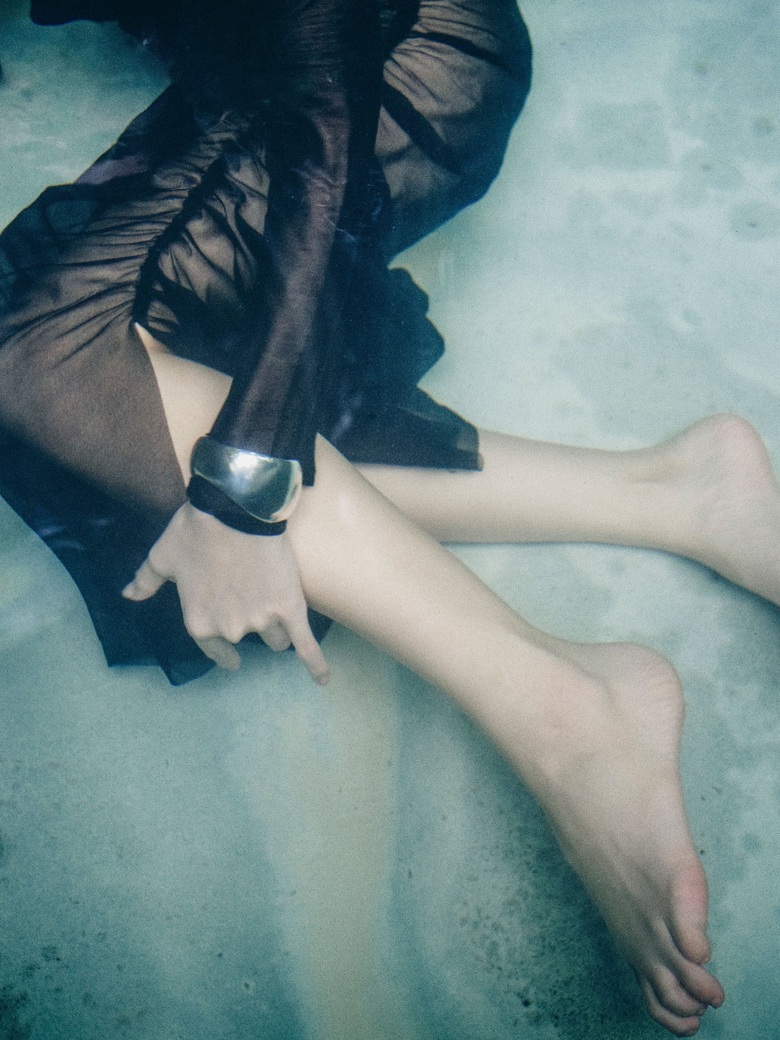 Woman in black dress wearing AGMES 0.925 sterling silver sculpted Jean cuff bracelet.