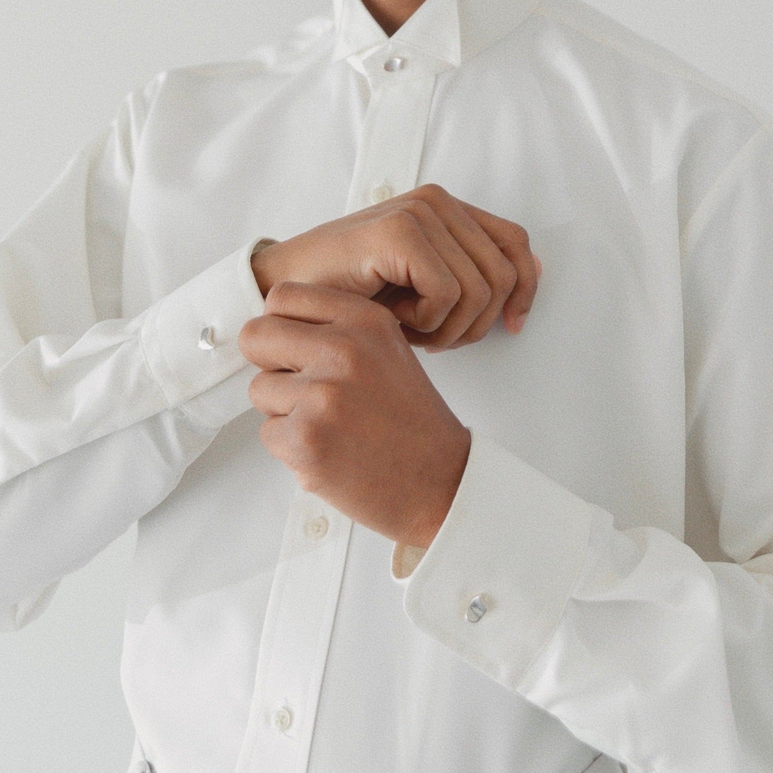 Model wearing AGMES .925 sterling silver sculptural heart Sum of Parts cufflinks on white dress shirt.