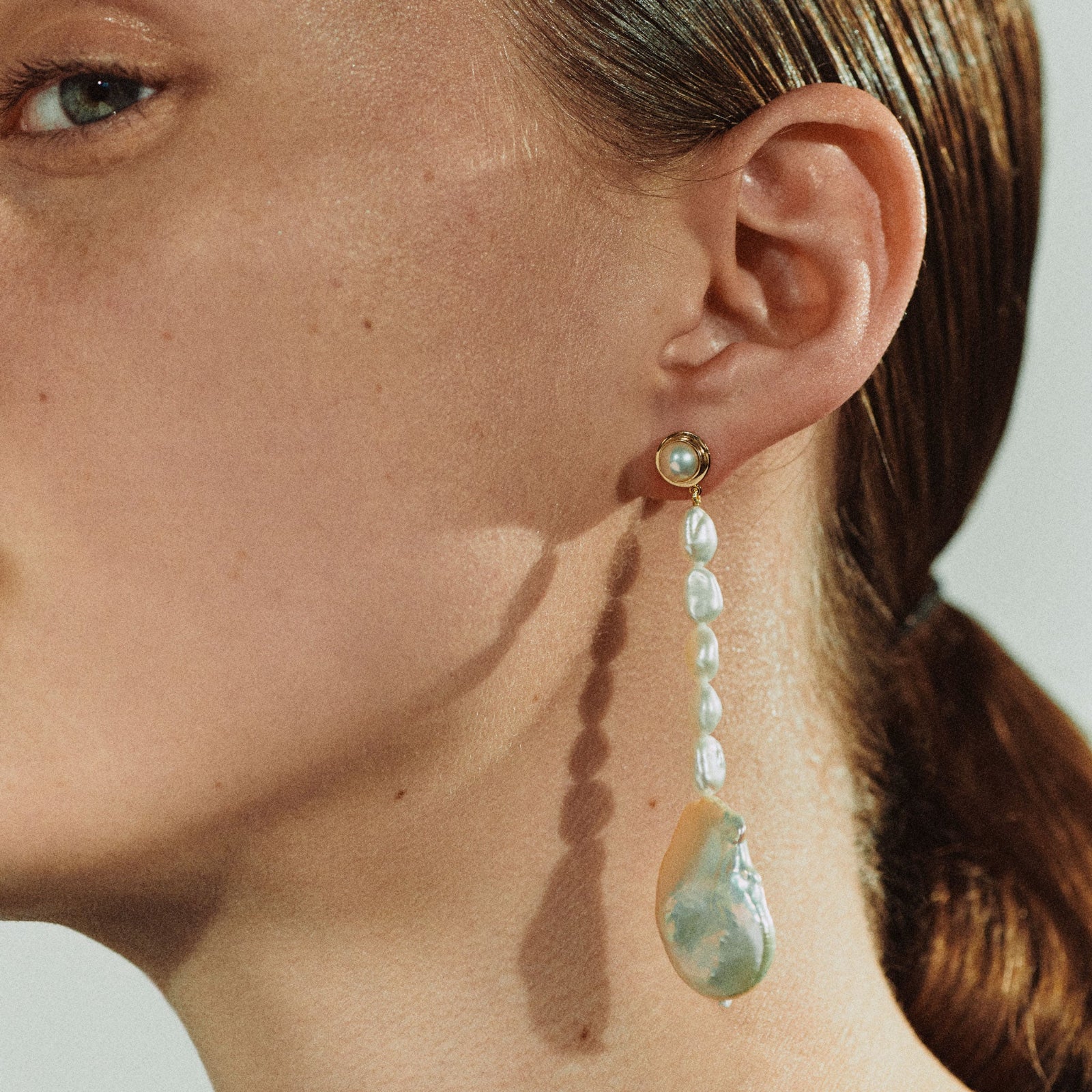 Woman wearing AGMES Emmanuelle earrings in yellow gold vermeil with freshwater pearls.