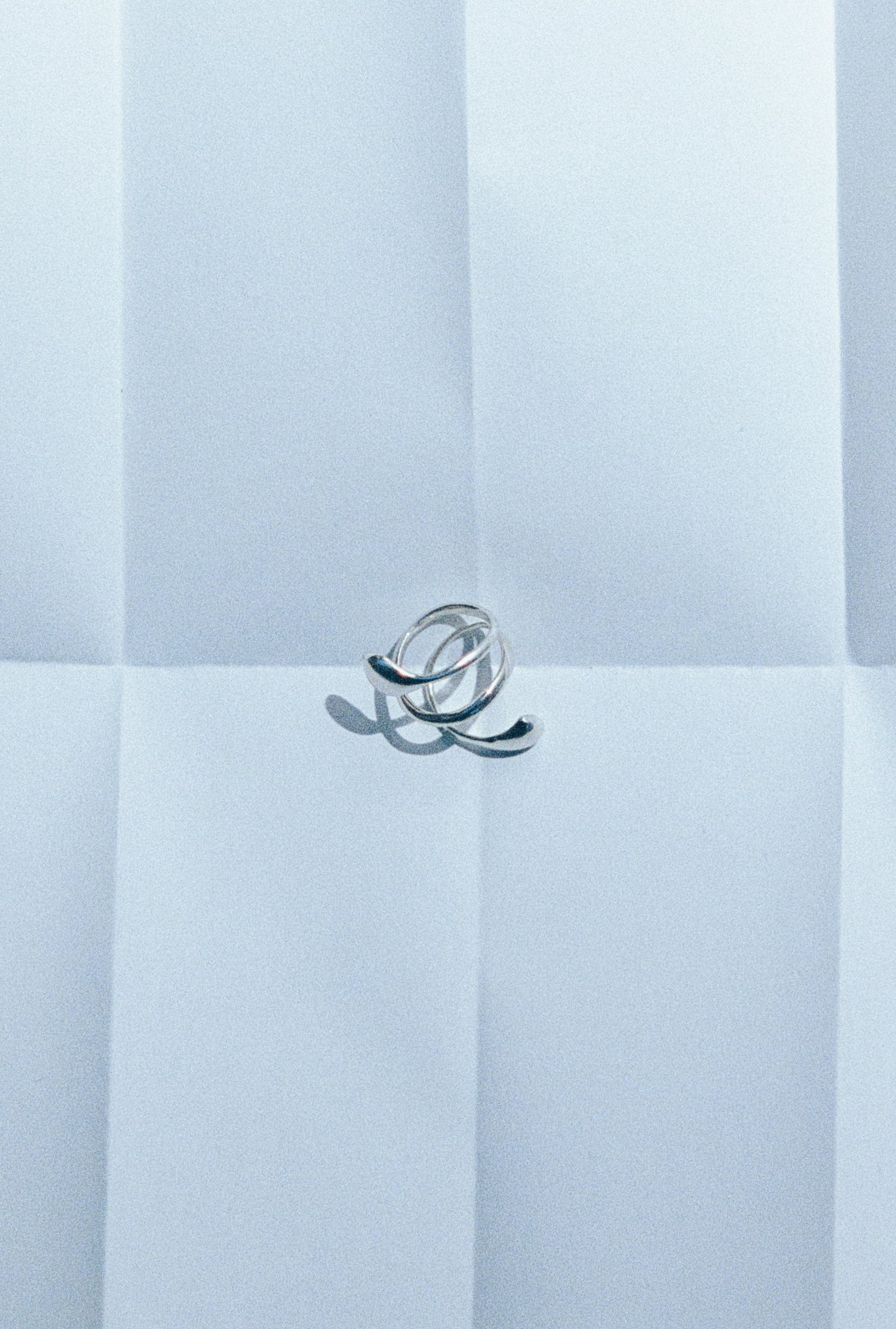 .925 sterling silver AGMES dual flora ring laying flat on paper, still life