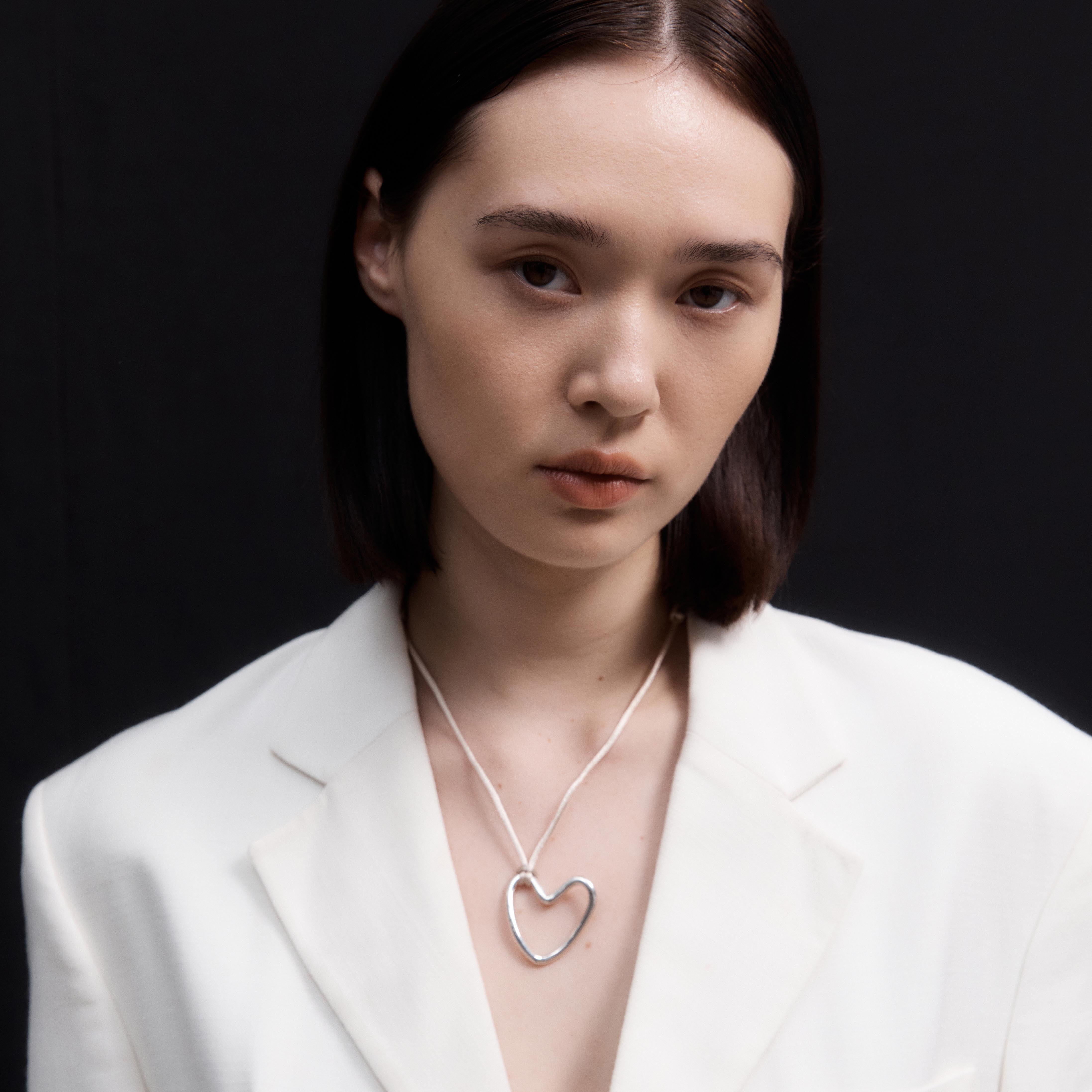 Woman wearing AGMES 18K Gold Vermeil Altun pendant with ivory satin cord. 