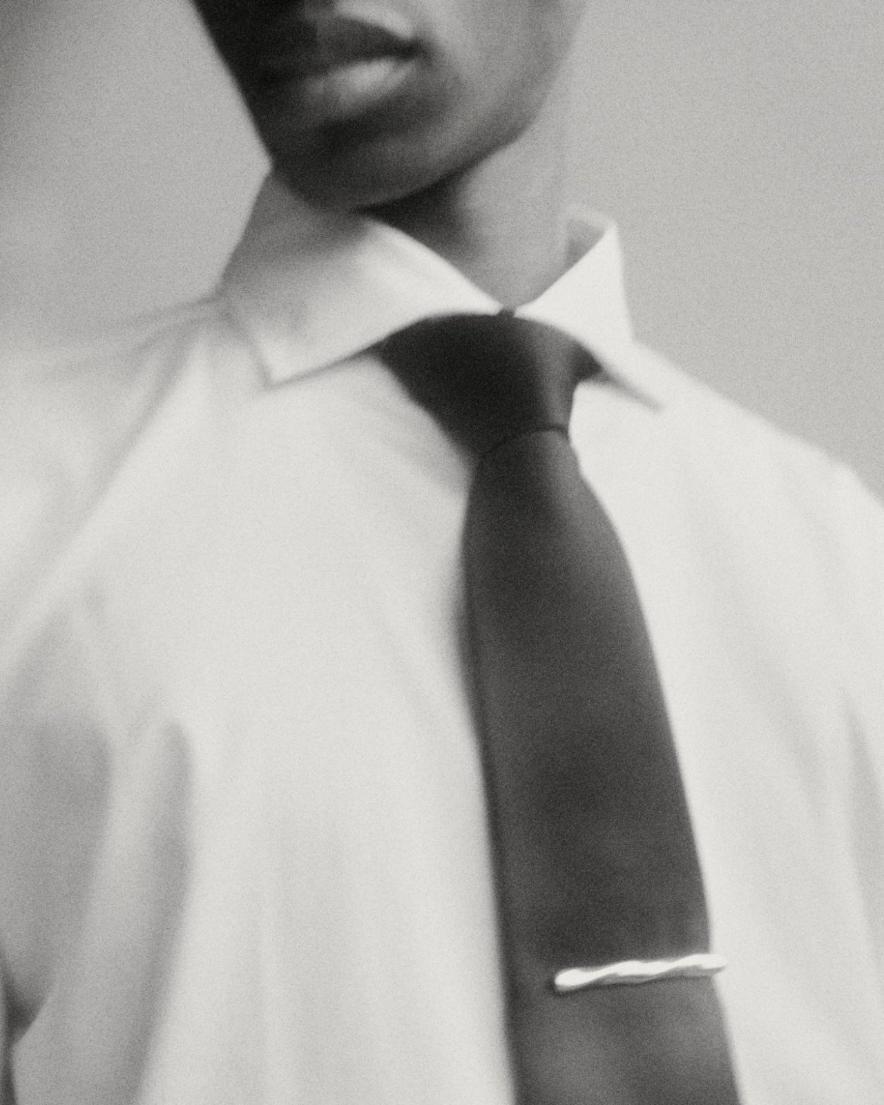 Model wearing AGMES .925 sterling silver sculptural Astrid Tie Clip on black tie. 