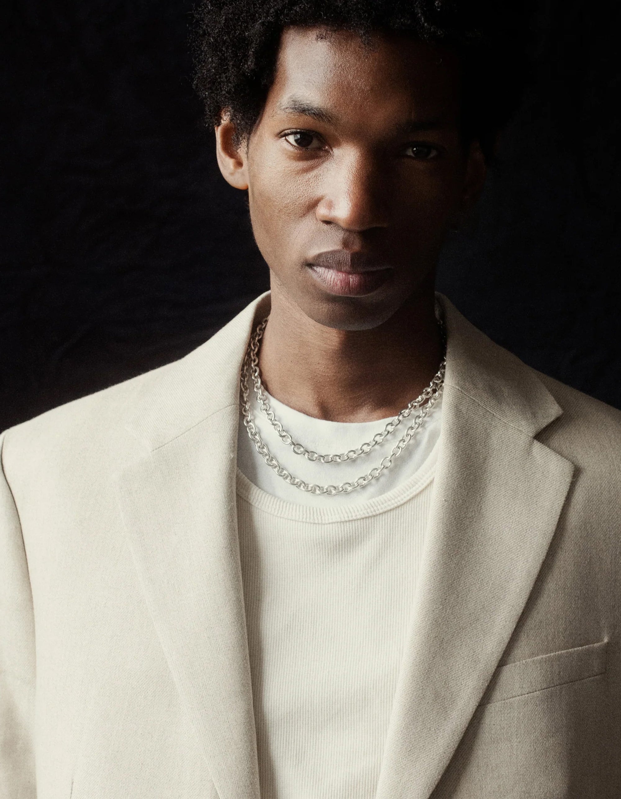 Man wearing two AGMES .925 sterling silver Classic Chain necklaces layered over a white shirt.