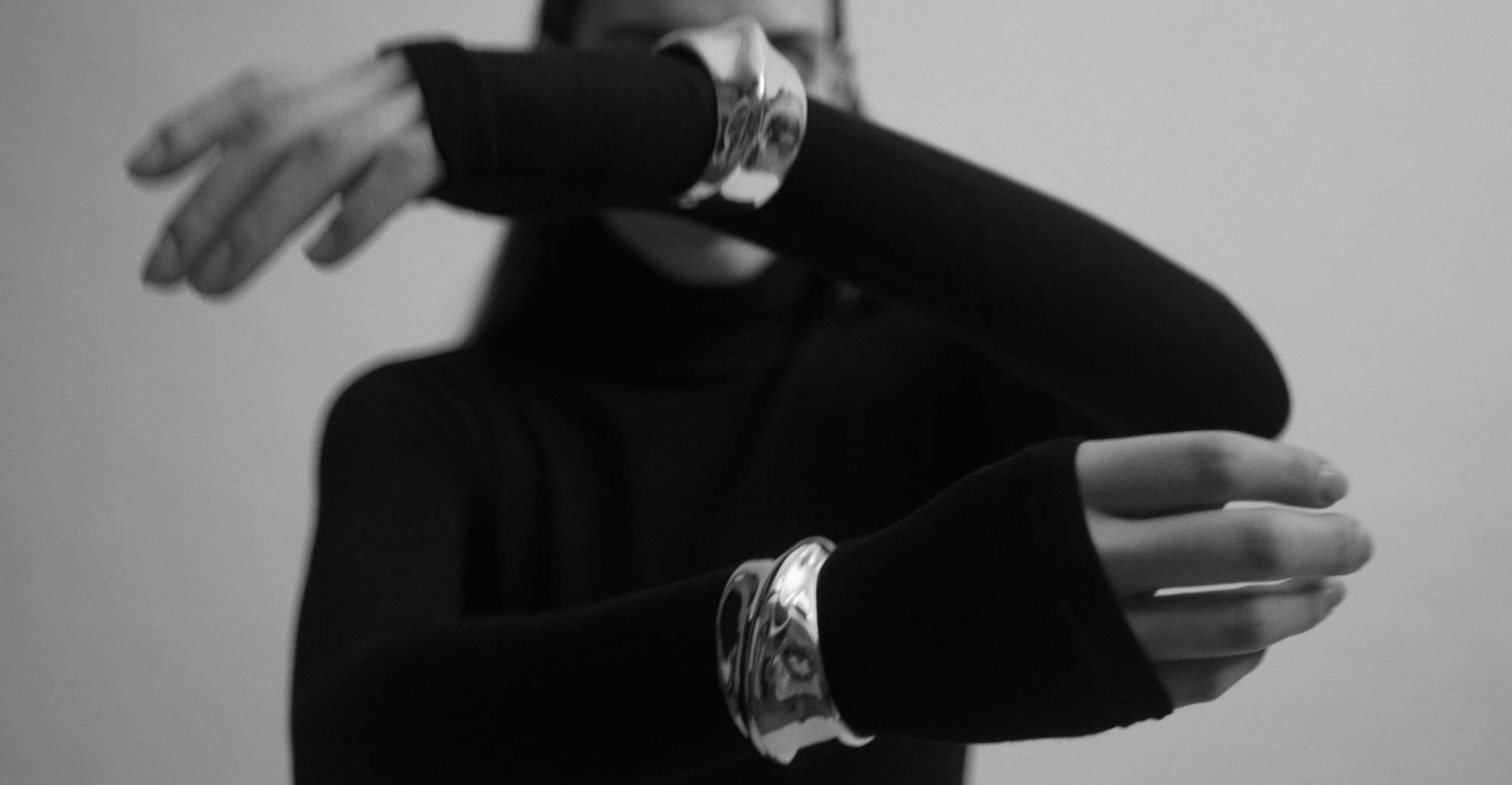 model wearing sterling silver cuff bracelets with chunky twist design over long sleeve shirt