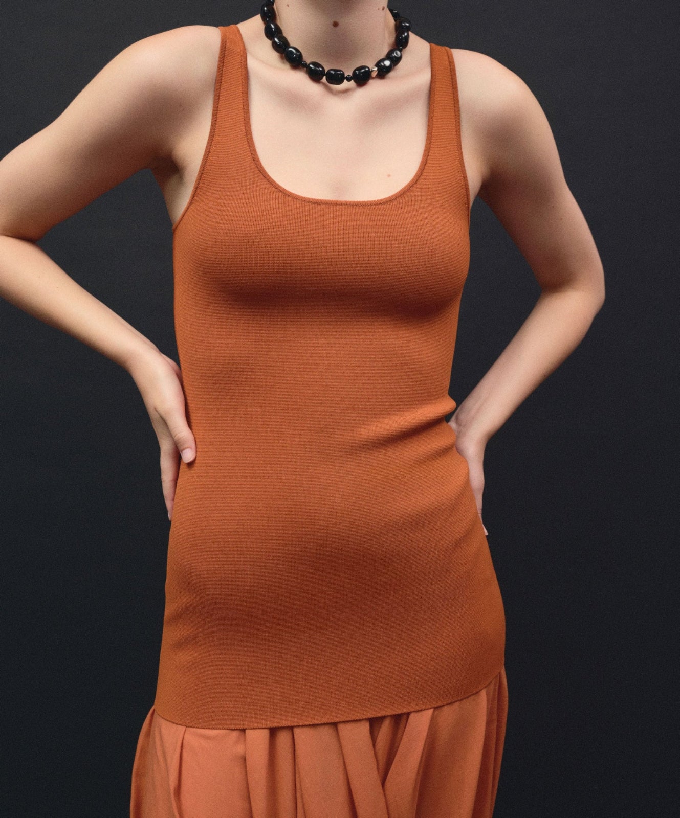 Black onyx beaded necklace with .925 sterling silver accent on model wearing orange dress