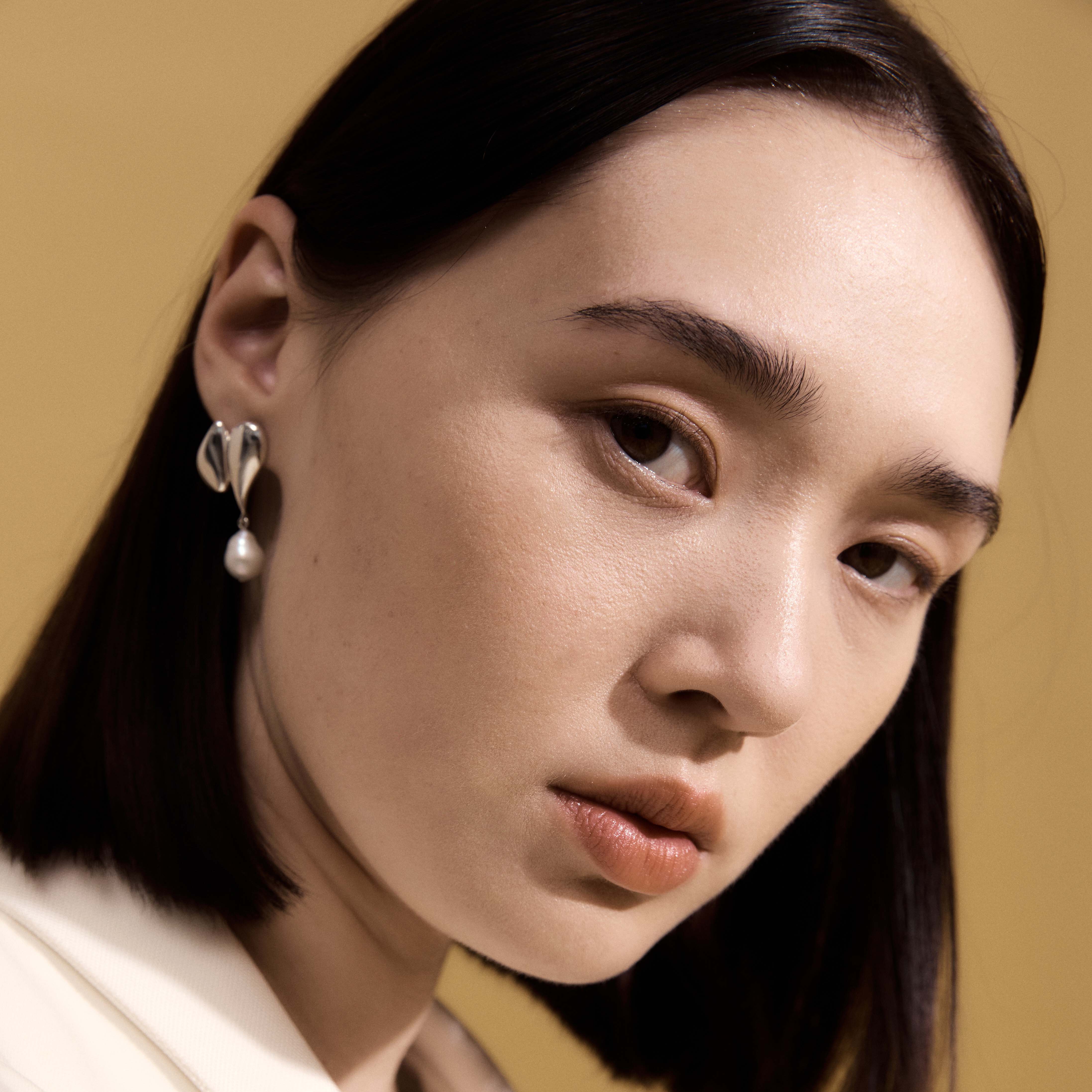 Woman wearing AGMES 0.925 sterling silver drop pearl Elvira earrings.