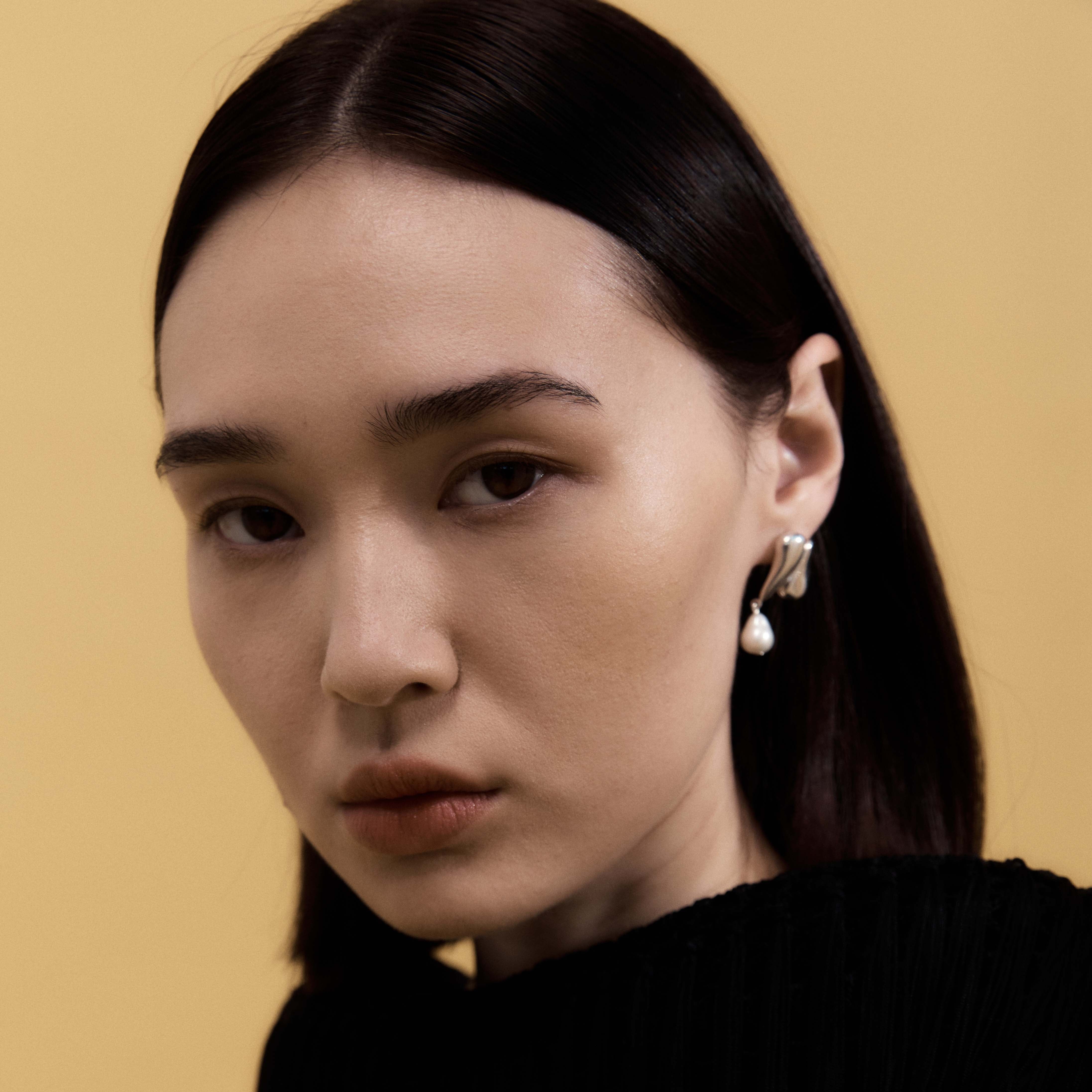 Woman wearing AGMES 0.925 sterling silver drop pearl Elvira earrings.