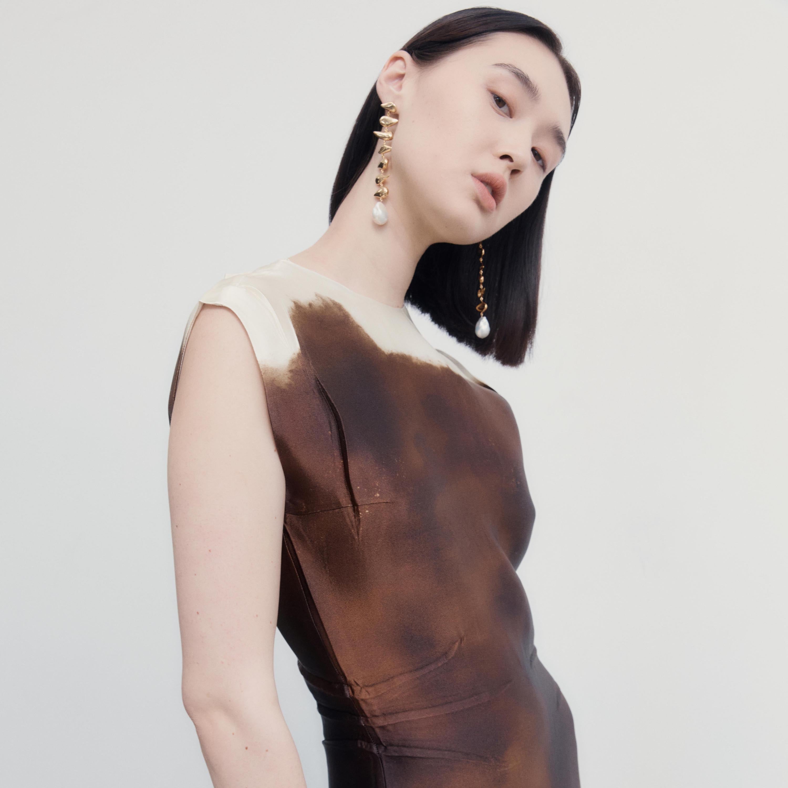 Woman wearing AGMES yellow gold vermeil long drop freshwater pearl Florence earrings.