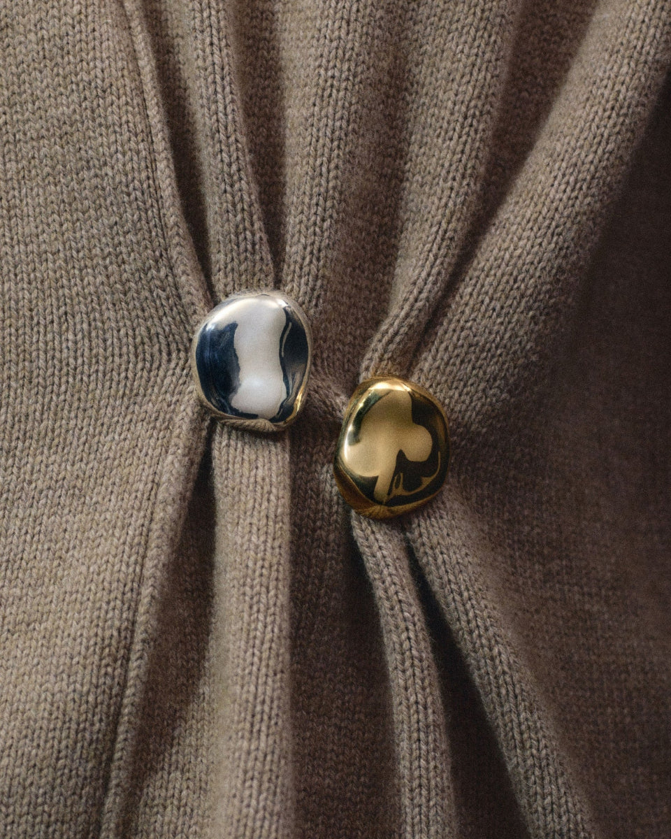 0.925 sterling silver and gold vermeil round naturally shaped brooches on tan knit background