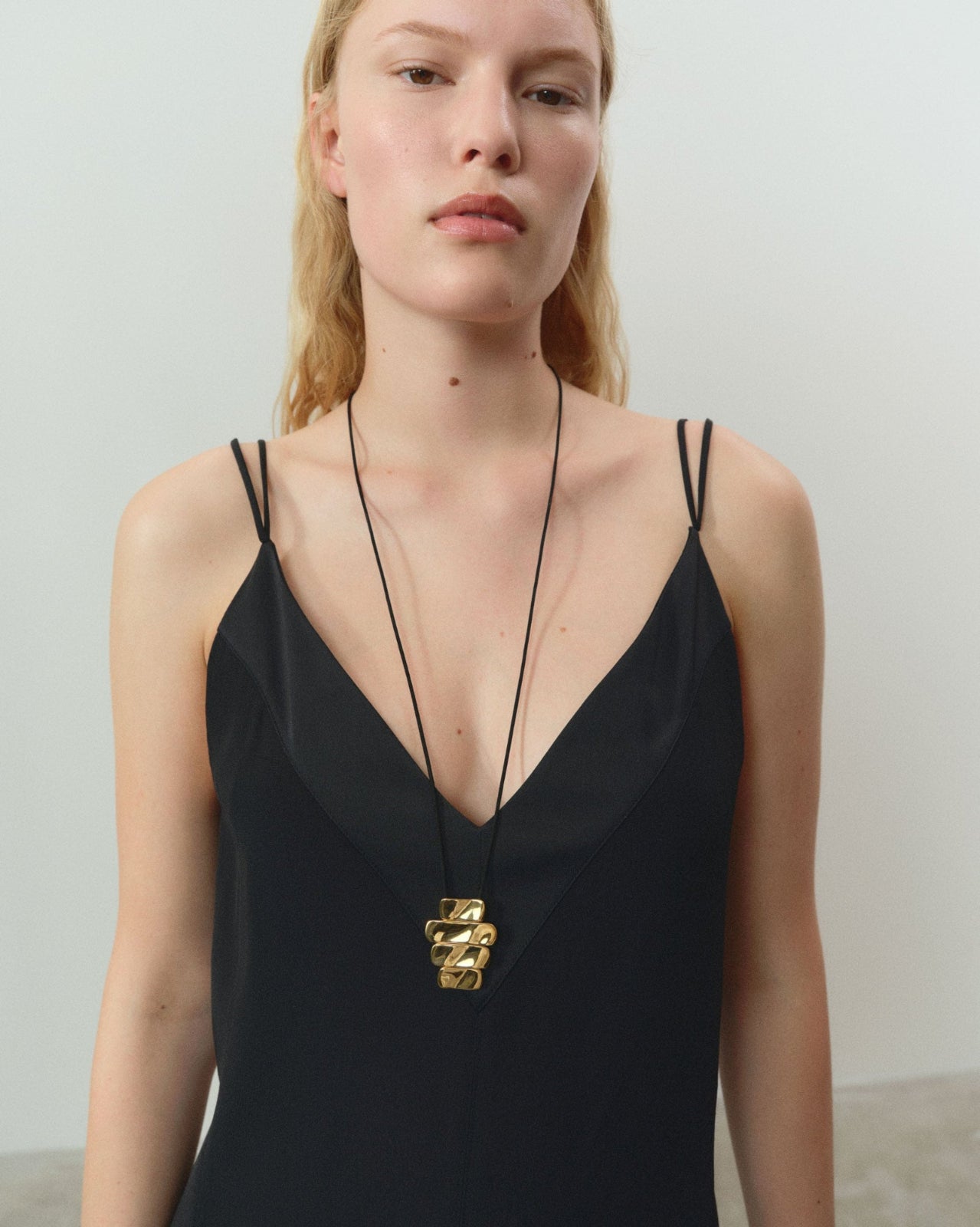 Women wearing AGMES 18k gold vermeil 4-tier Ilona Pendant on black suede cord
