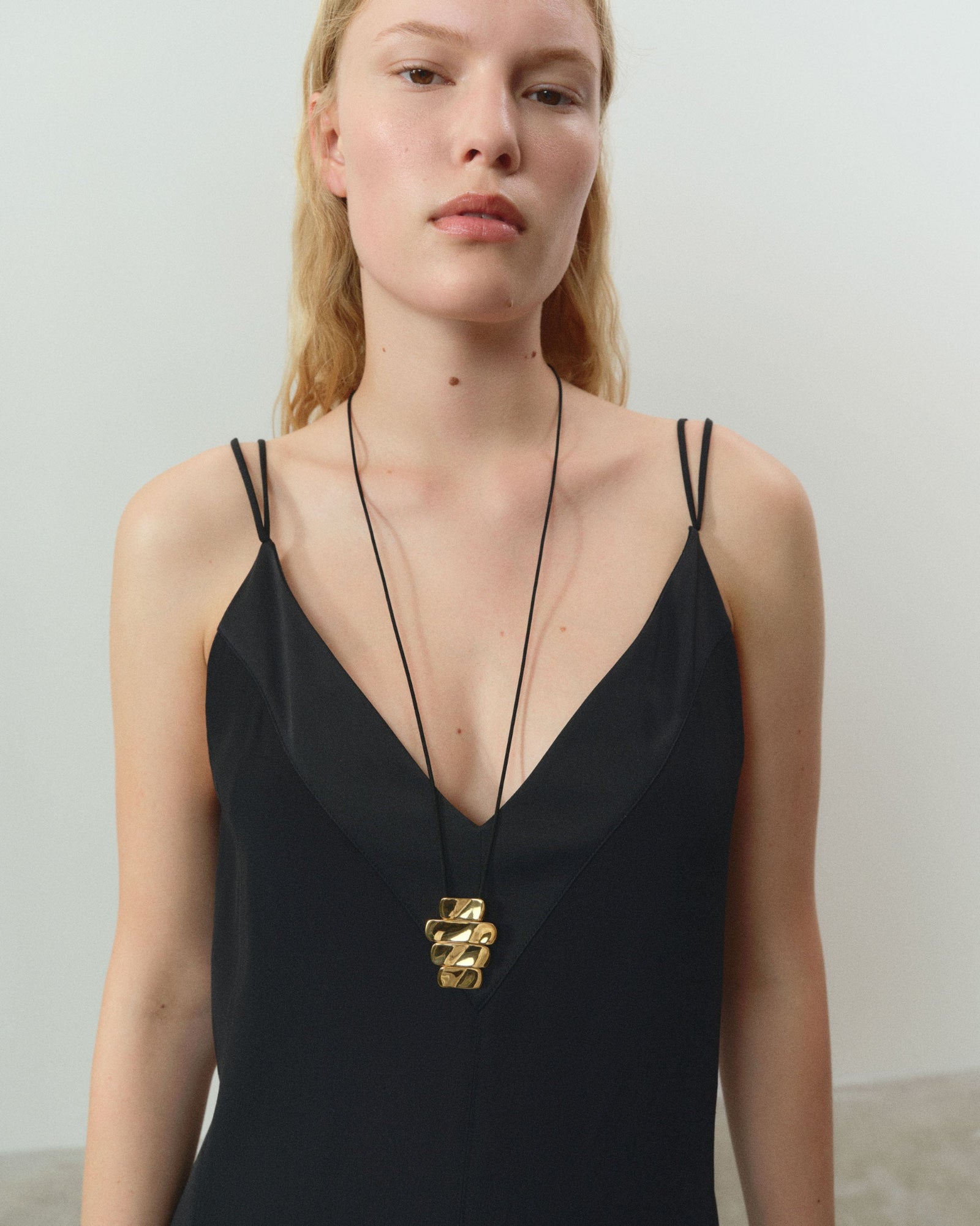 Women wearing AGMES 18k gold vermeil 4-tier Ilona Pendant on black suede cord