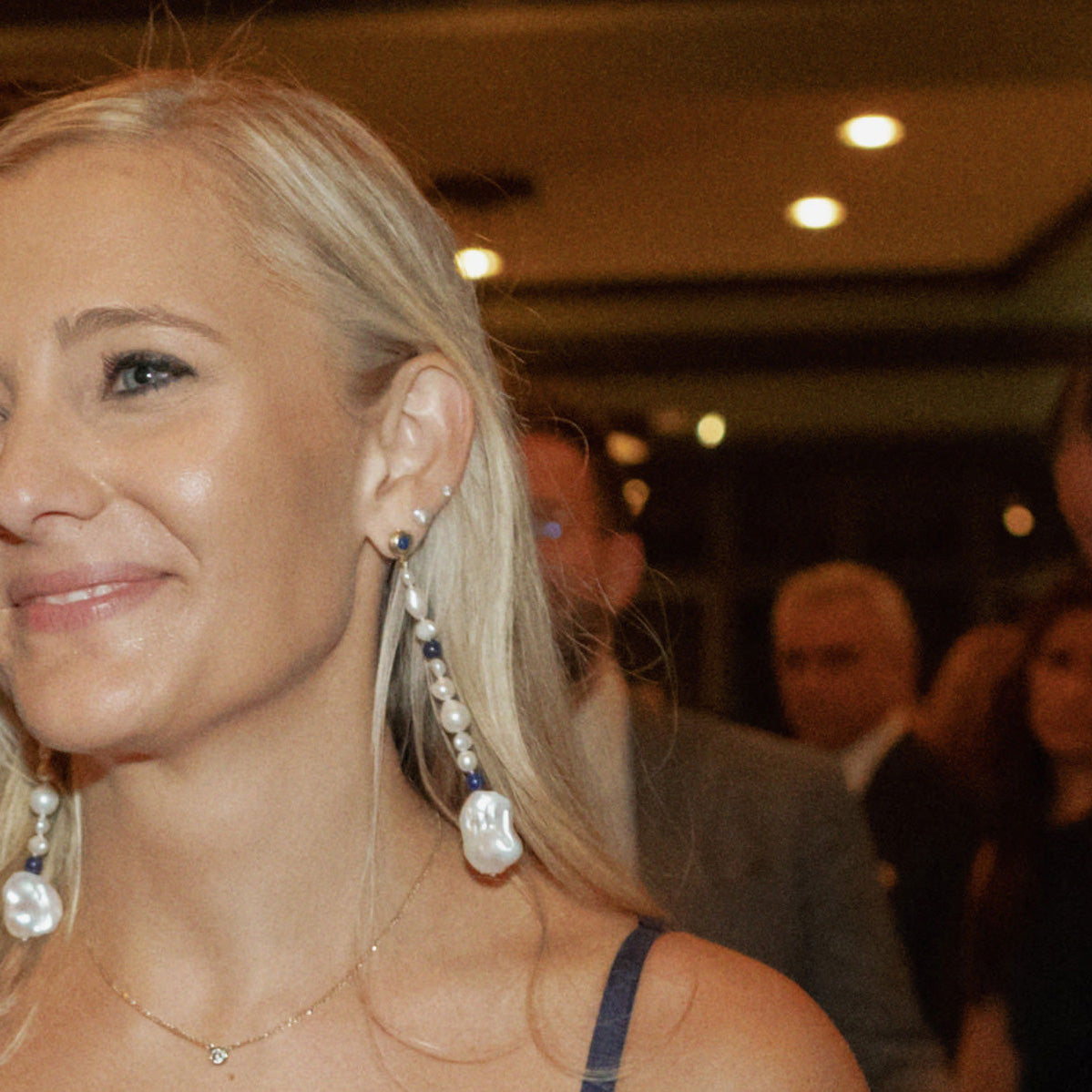 Woman wearing AGMES 18K Gold Vermeil Long Kait Earrings with Baroque Pearl and Lapis Stone. 