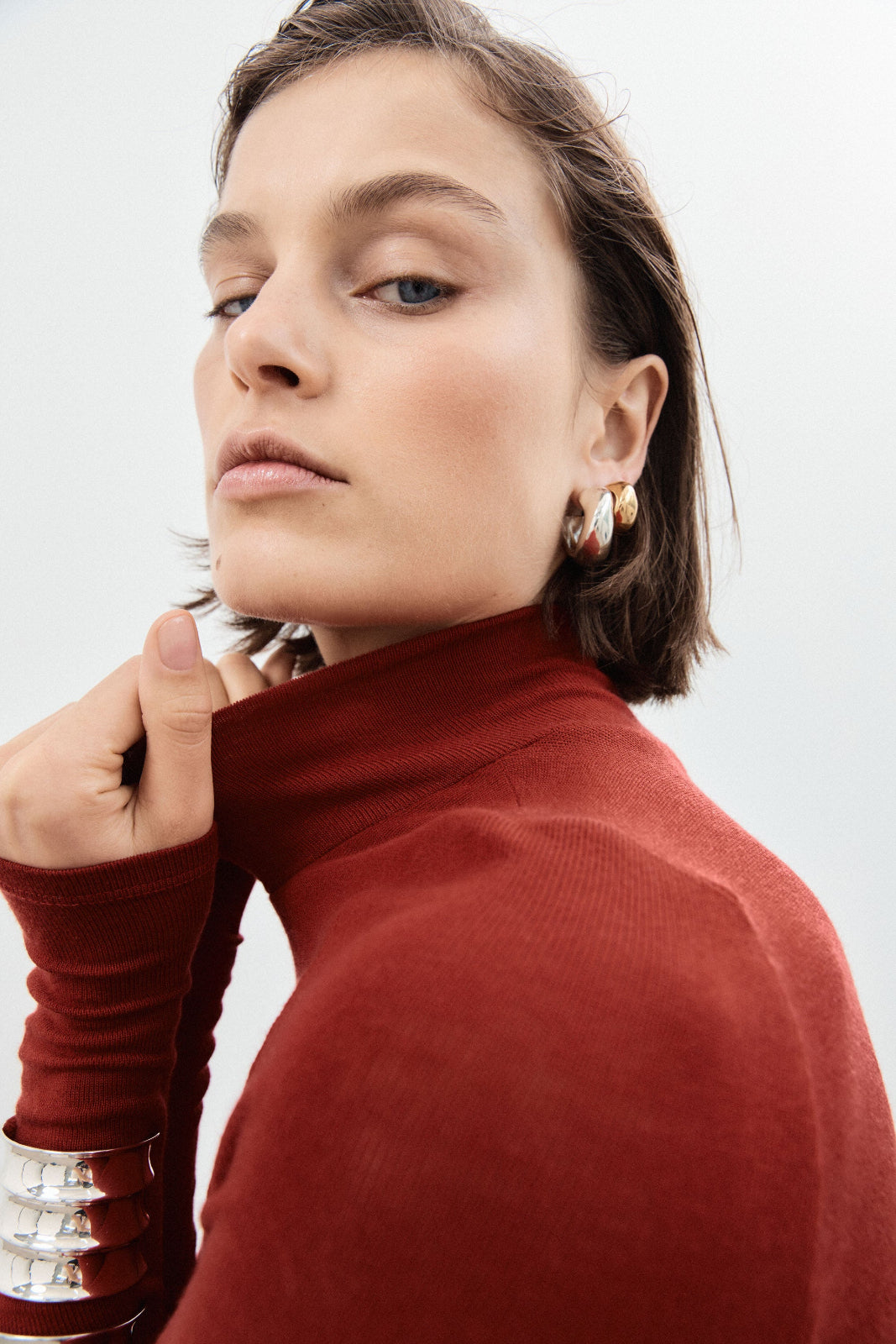 Woman wearing AGMES 0.925 sterling silver medium hoop earrings.