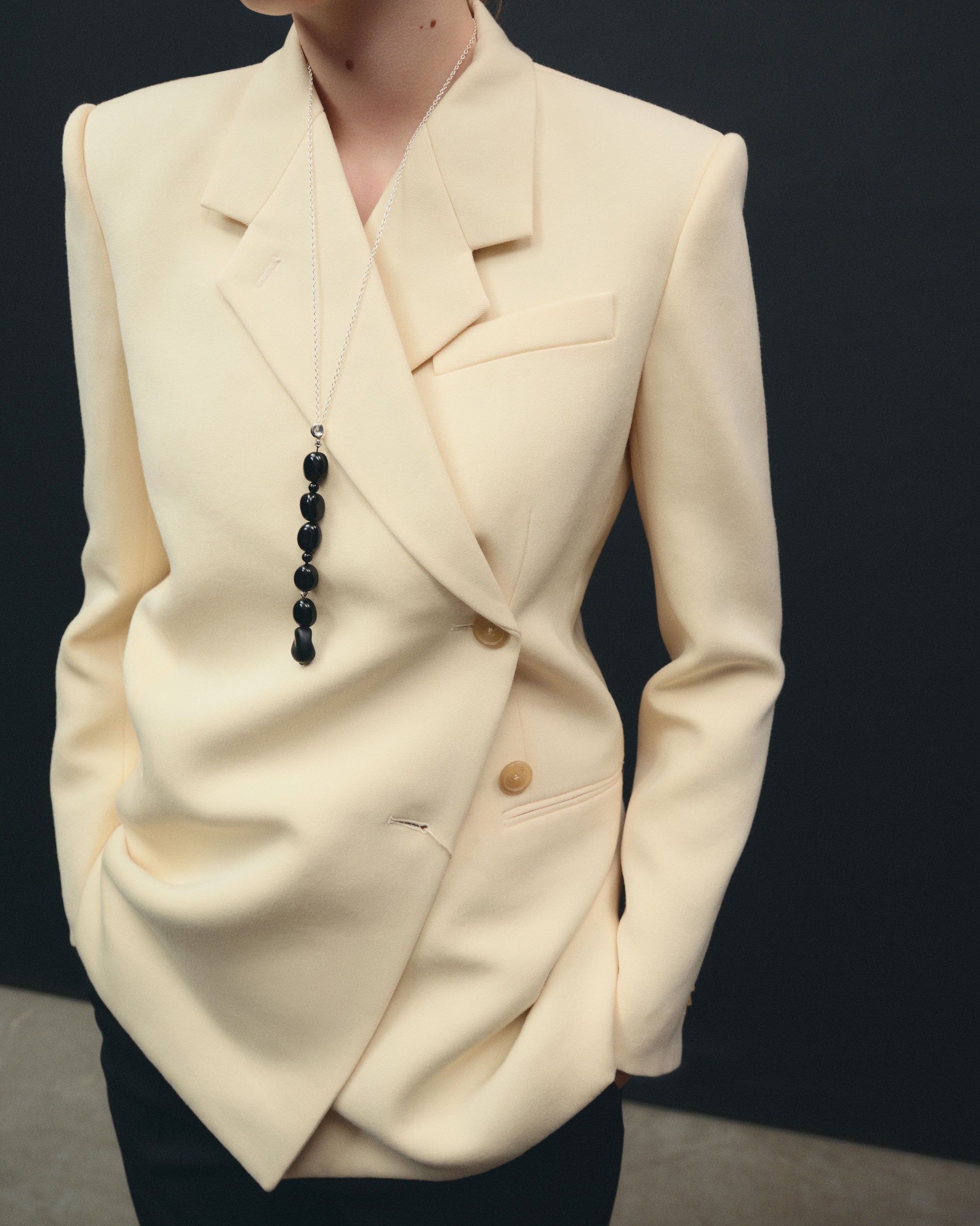 Black Onyx beaded pendant drop necklace on sterling silver chain layered on woman wearing cream blazer