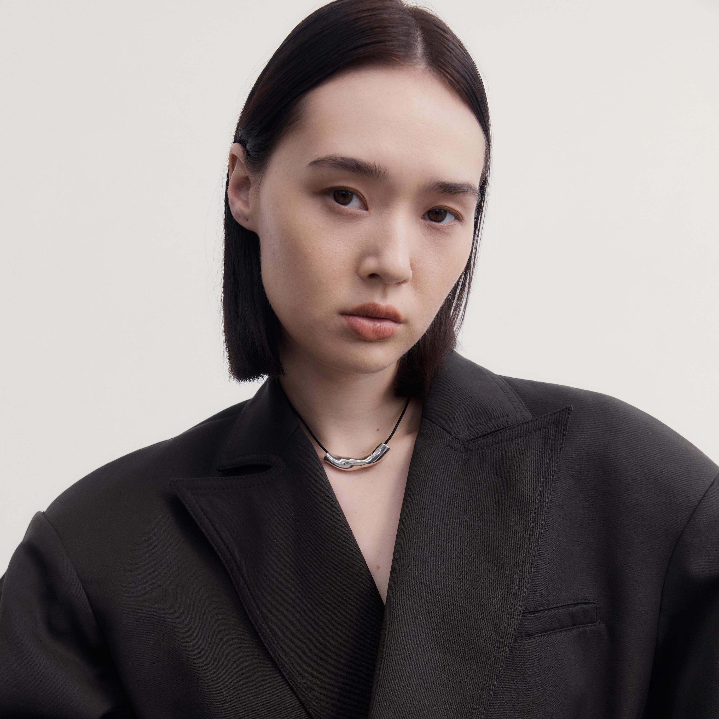 Woman wearing AGMES .925 Sterling Silver Small Astrid Pendant on Black Suede Cord. 