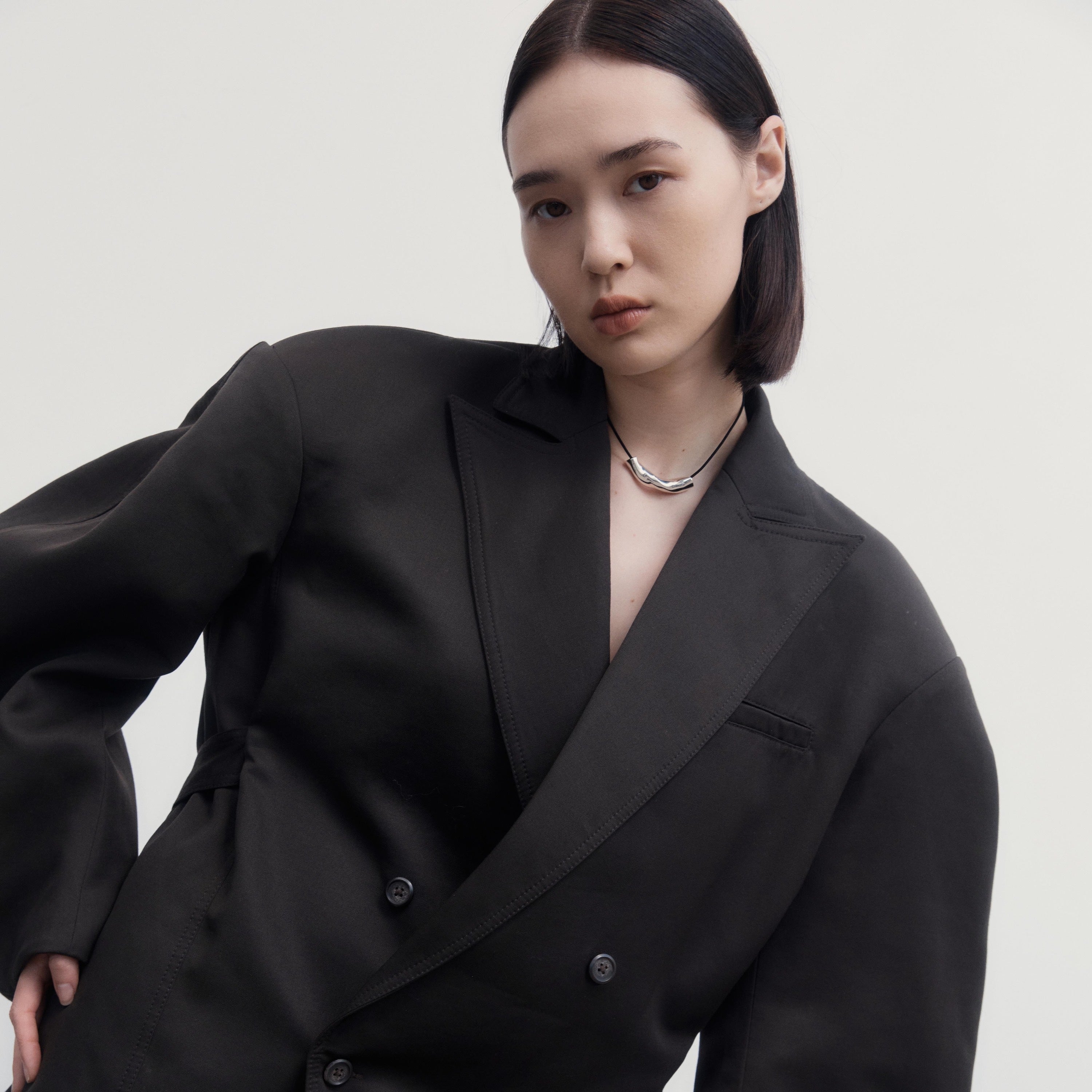 Woman wearing AGMES .925 Sterling Silver Small Astrid Pendant on Black Suede Cord. 