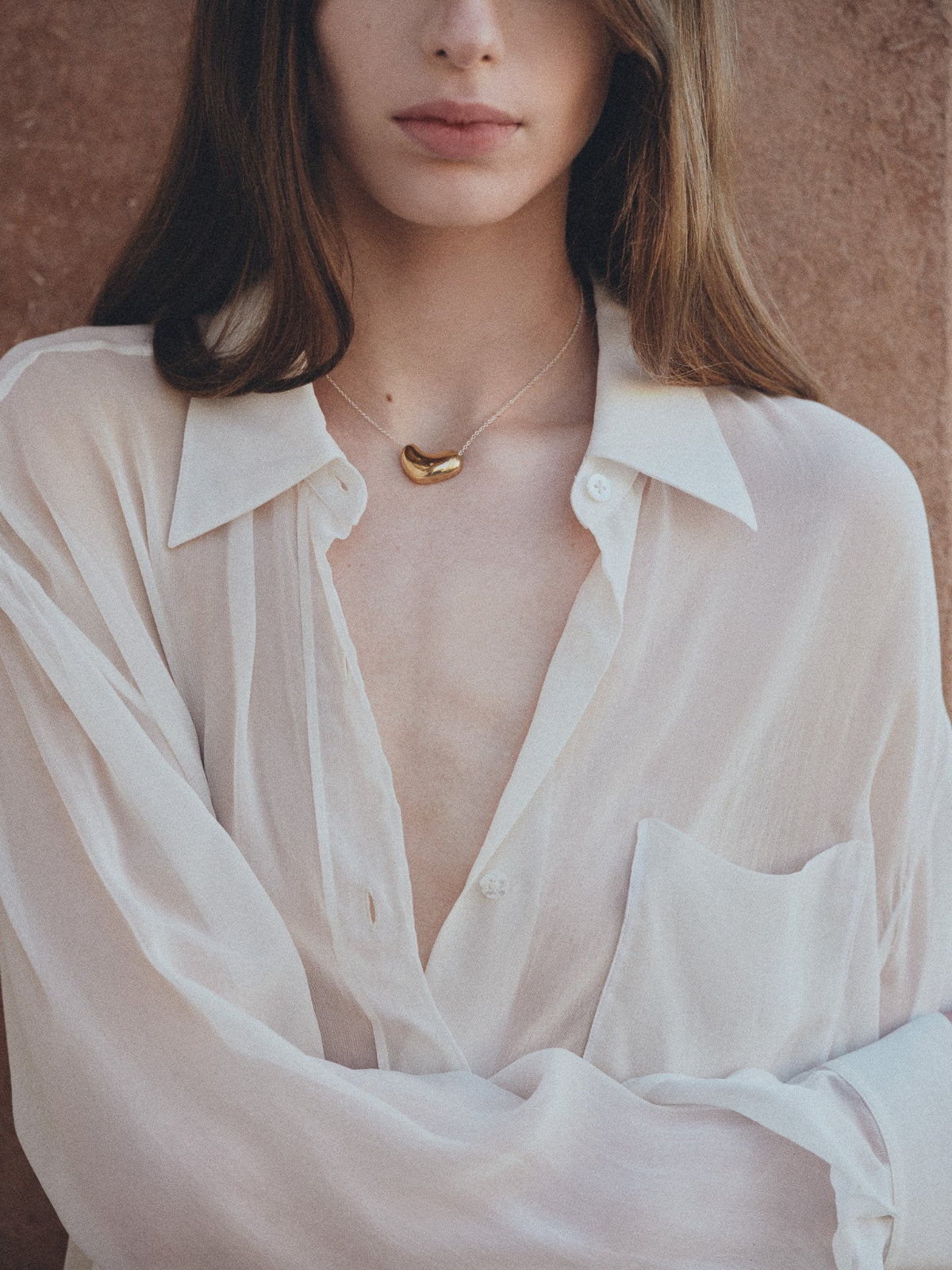 Woman wearing AGMES 18K Gold Vermeil Small Sculpted Heart Pendant Necklace. 
