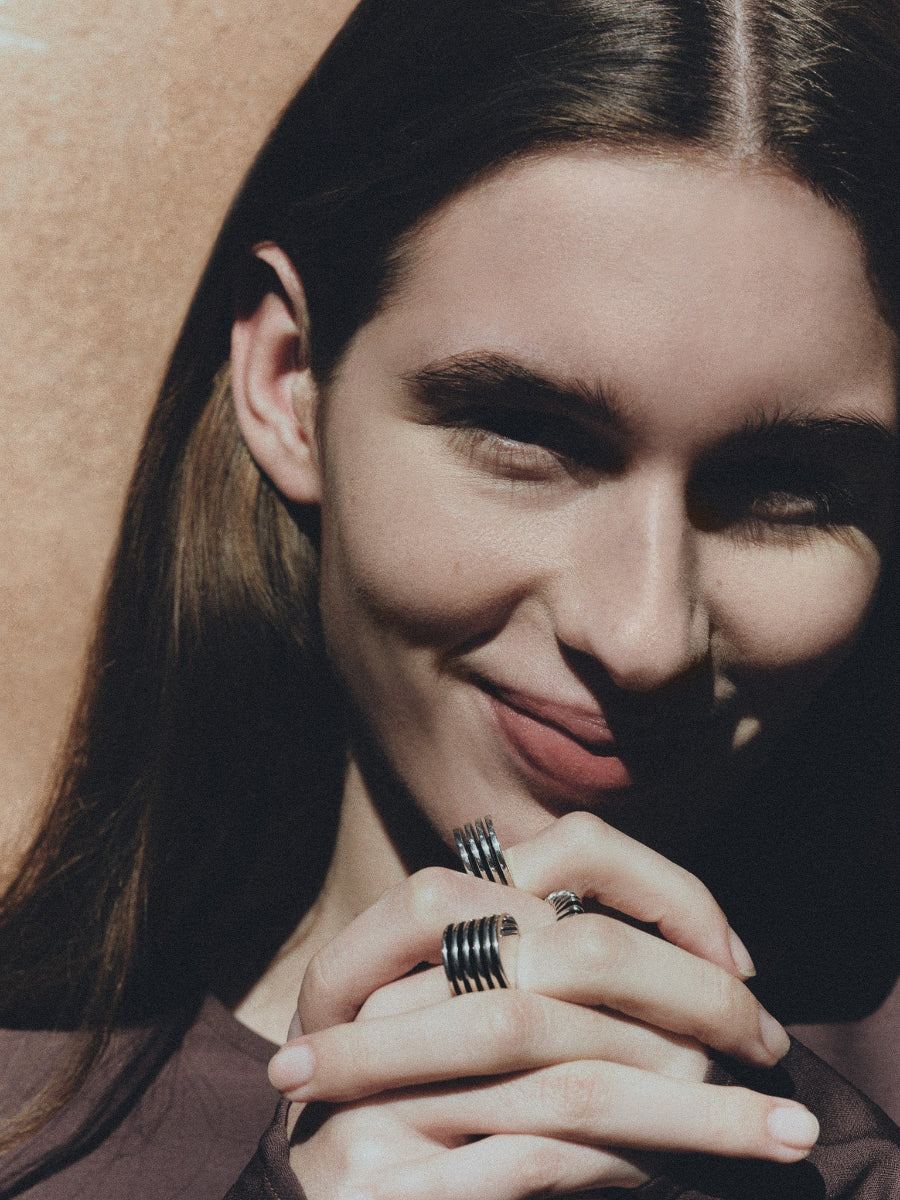 Woman wearing AGMES .925 Sterling Silver Wide Boeri Ring, Bertrand Ring, and Boeri Ring. 