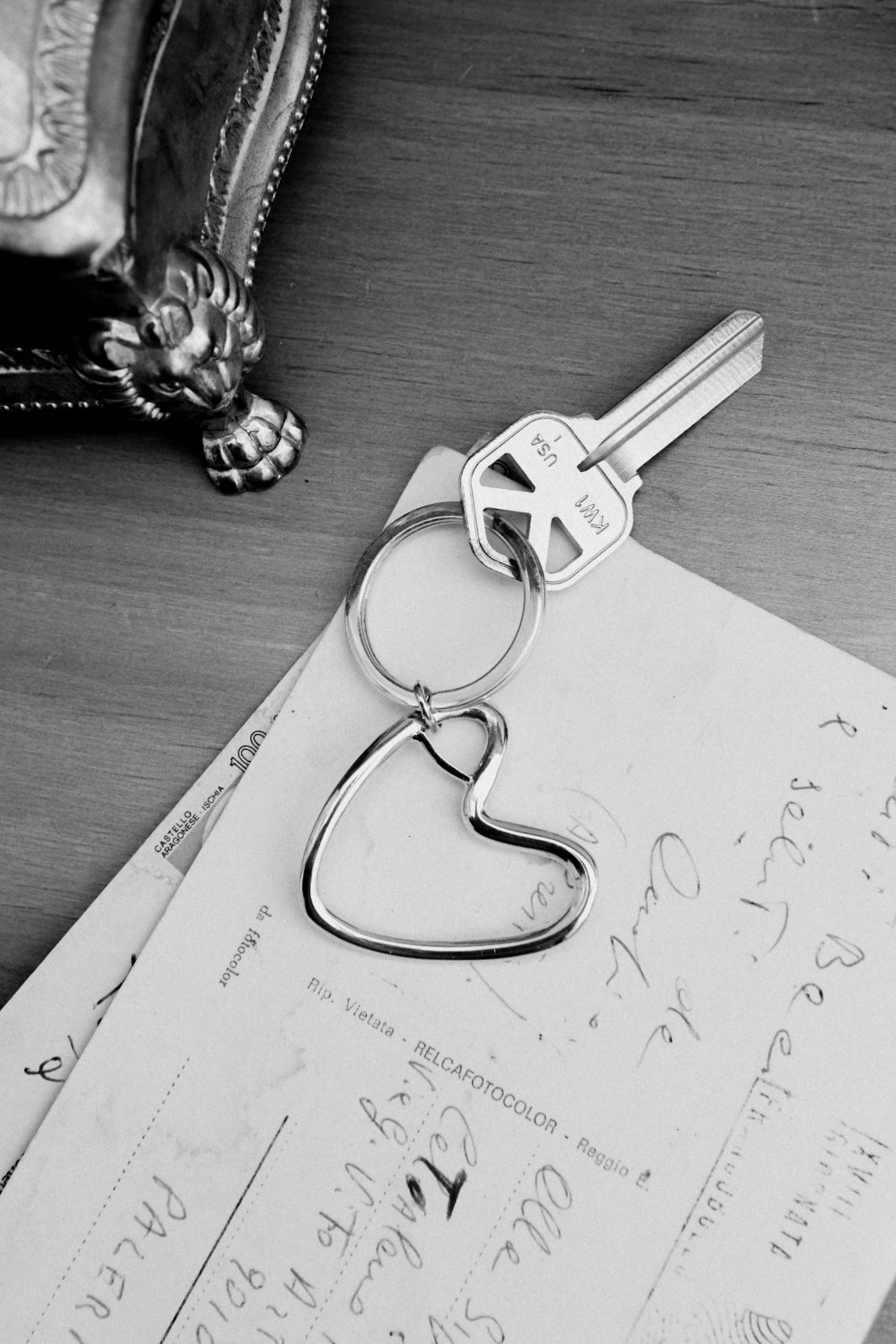 AGMES .925 sterling silver Altun keychain on top of postcard and wood desk.