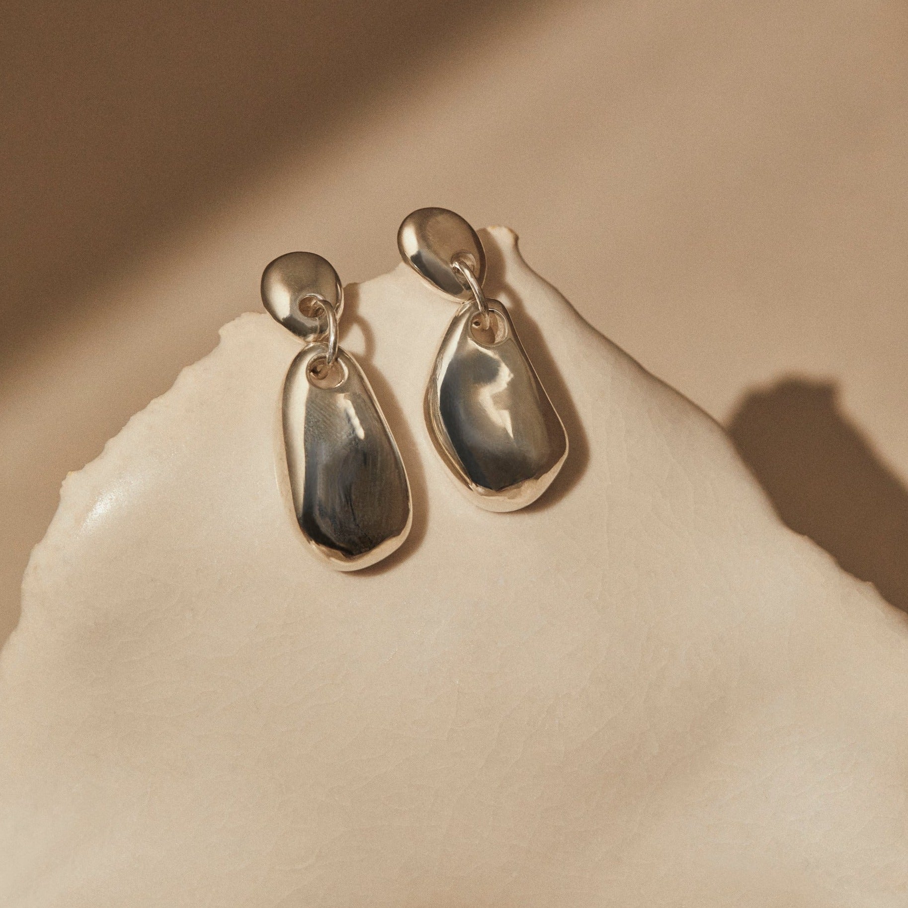 AGMES 0.925 sterling silver sculpted round drop earrings.