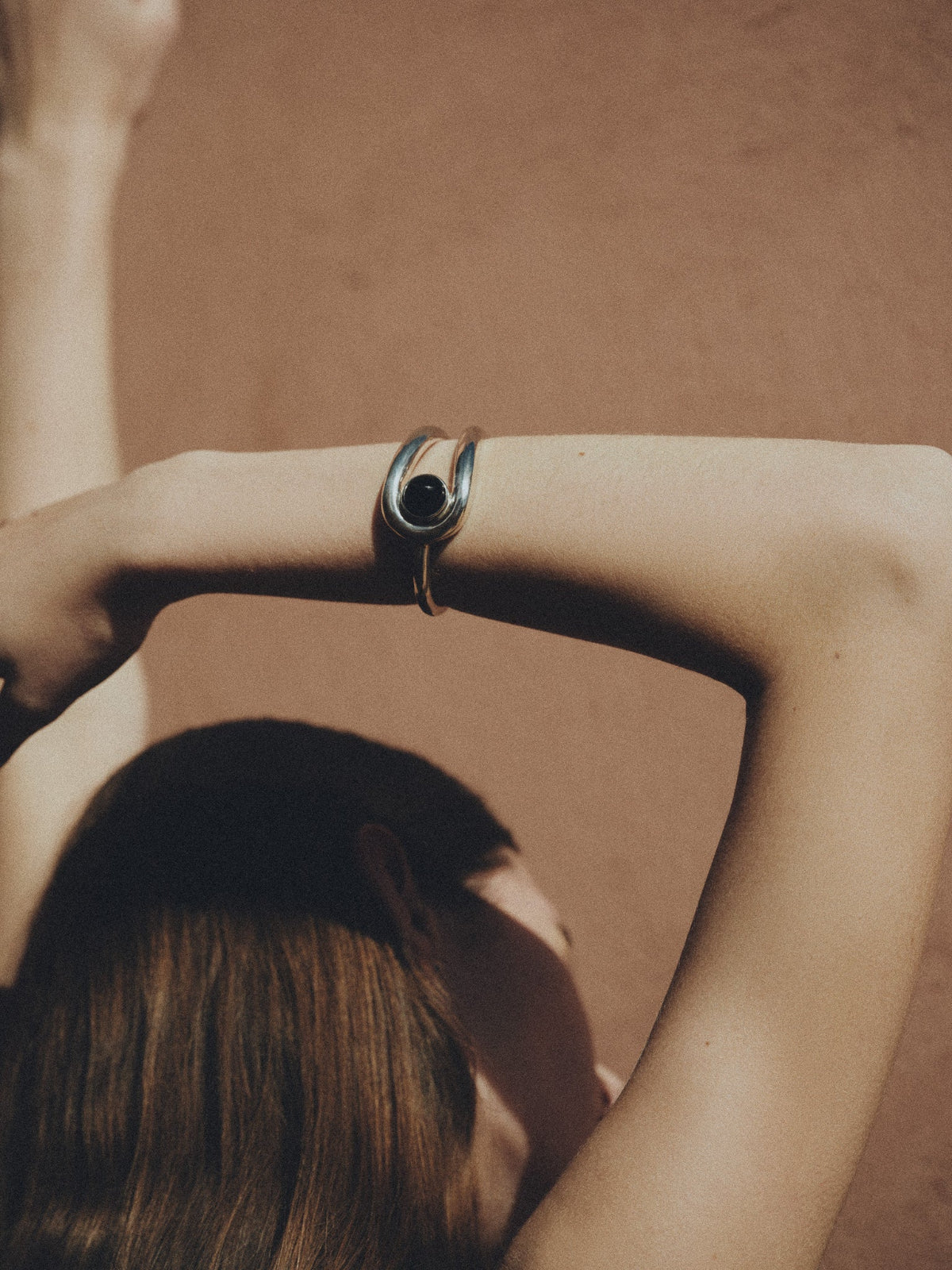 Woman wearing AGMES 0.925 sterling silver Becky cuff bracelet with lapis stone in front of natural background.