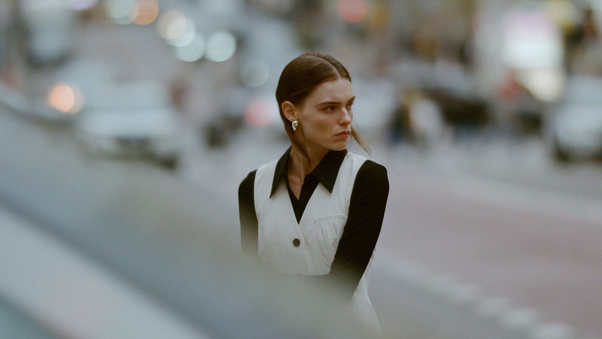 Woman wearing sterling silver oval Catherine Earrings in busy New York City street