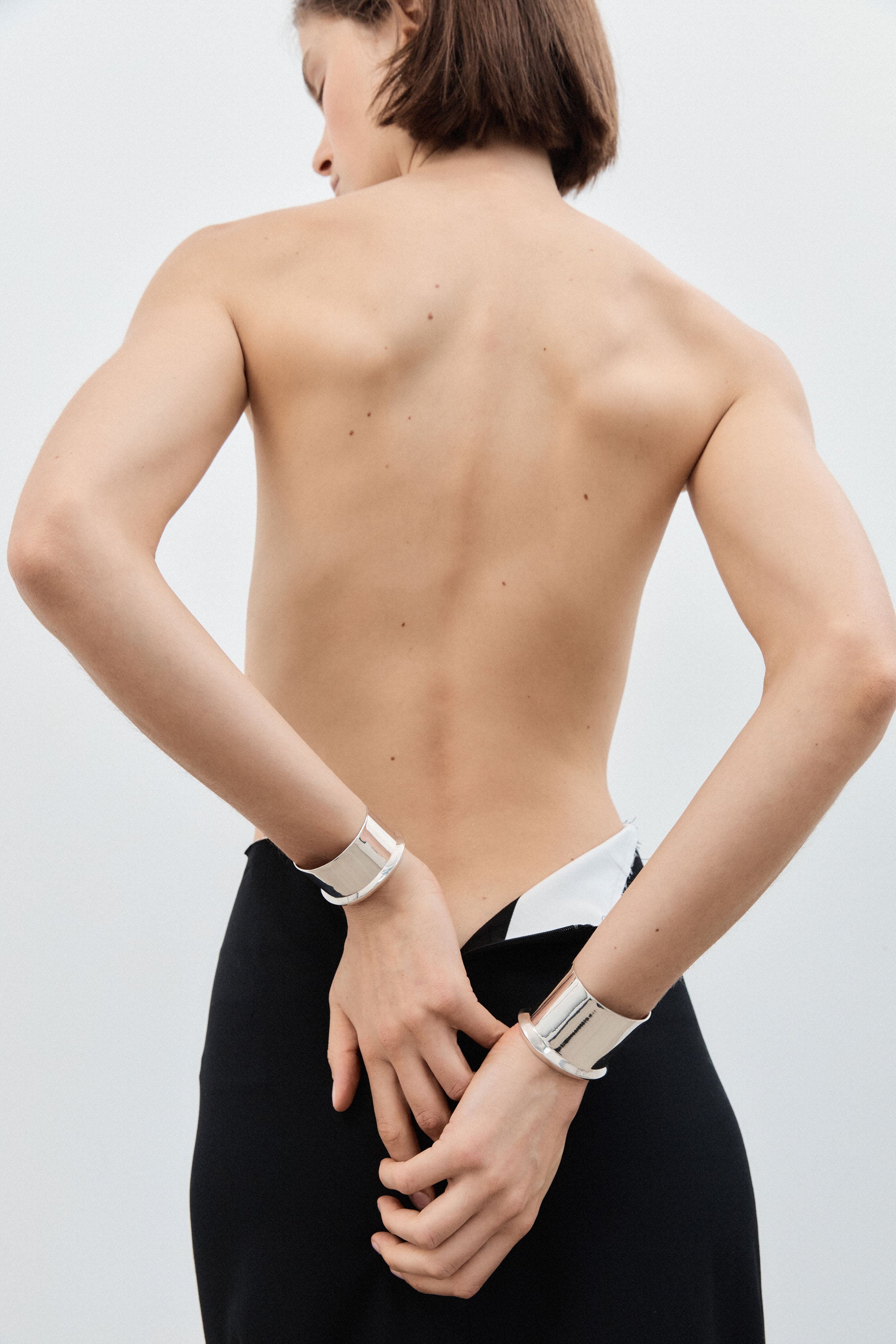 Woman wearing AGMES 0.925 sterling silver simple and modern cuff set with a geometric scallop detail on edges.