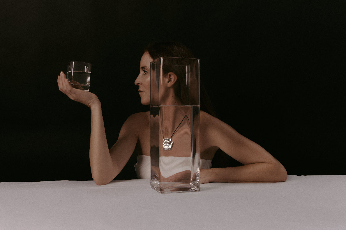 Woman wearing AGMES .925 sterling silver 4-tier Ilona Pendant on black suede cord.