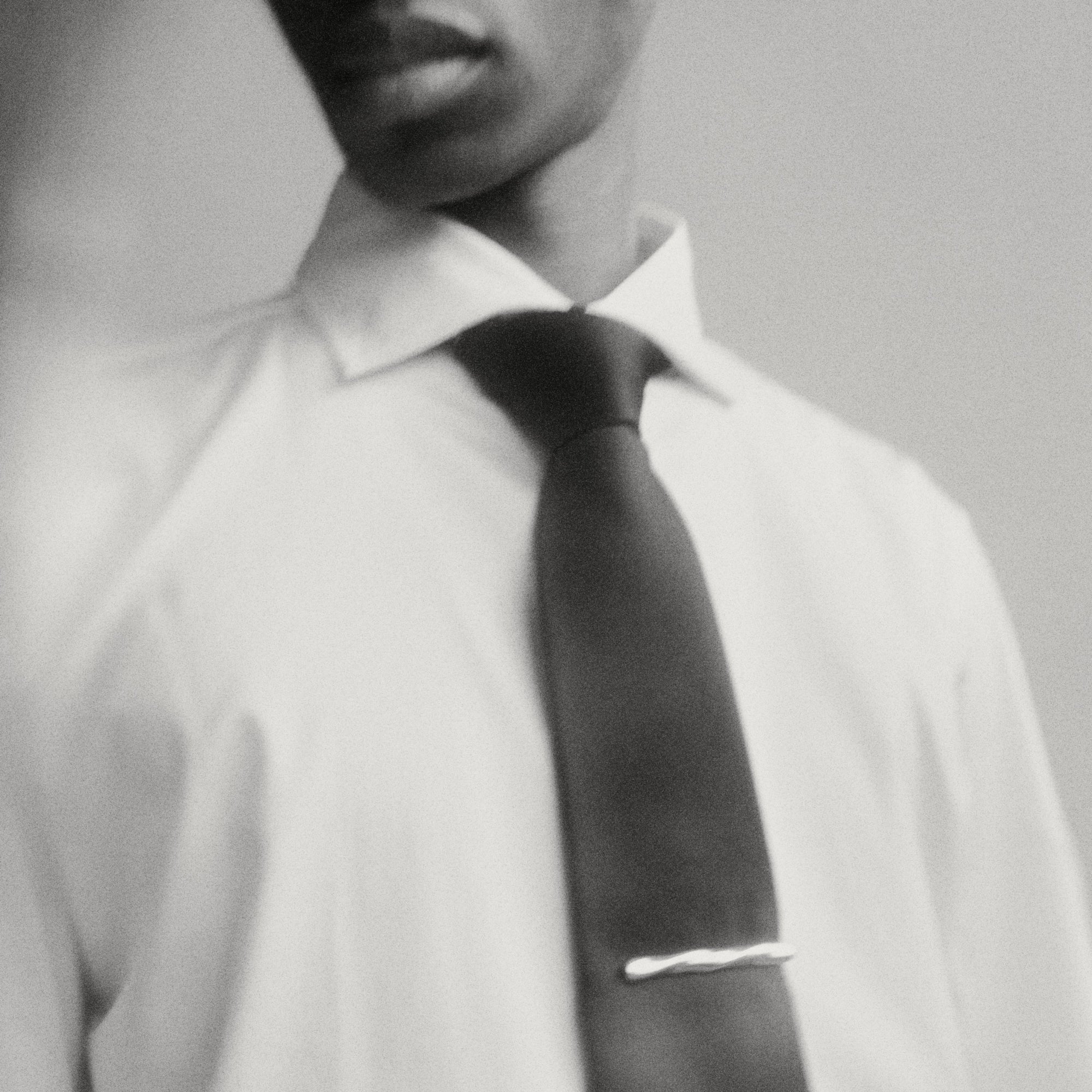 Male model wearing a black tie with a sterling silver Astrid Tie Clip on it