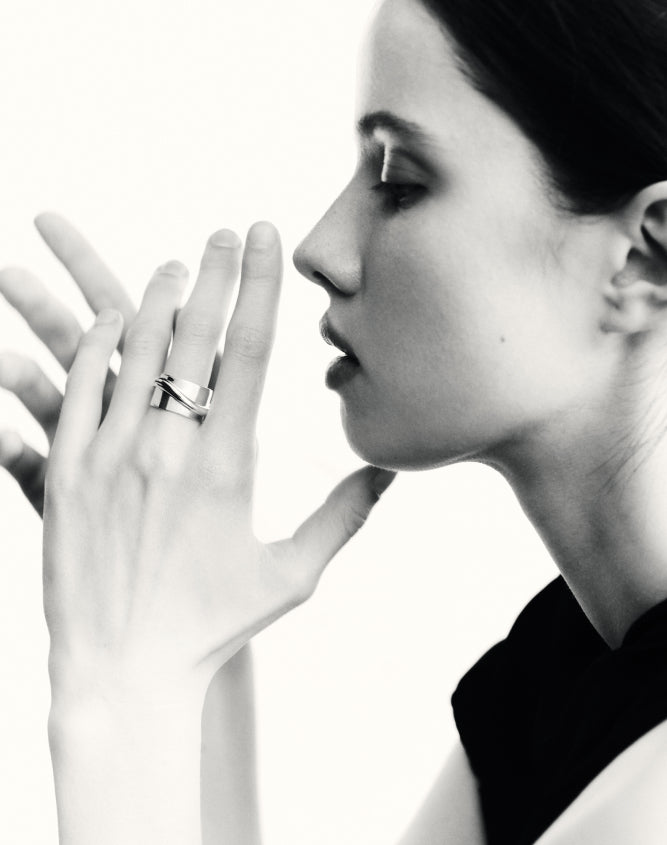 Woman wearing AGMES .925 sterling silver Large Arden Cigar Band Ring on ring finger, black & white